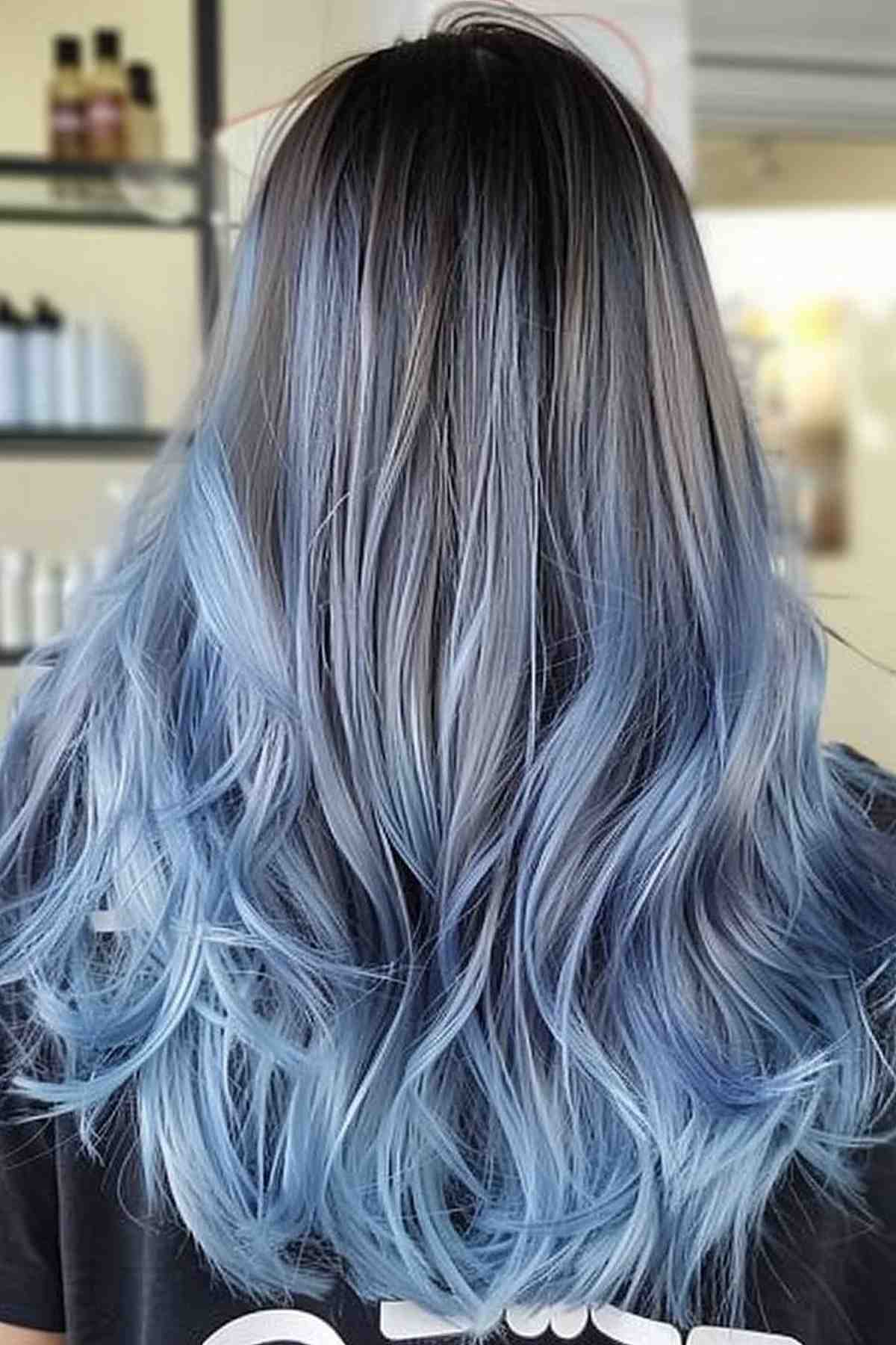 Mid-length hair transitioning from dark roots to a blue and grey ombre, capturing the essence of an oceanic palette.