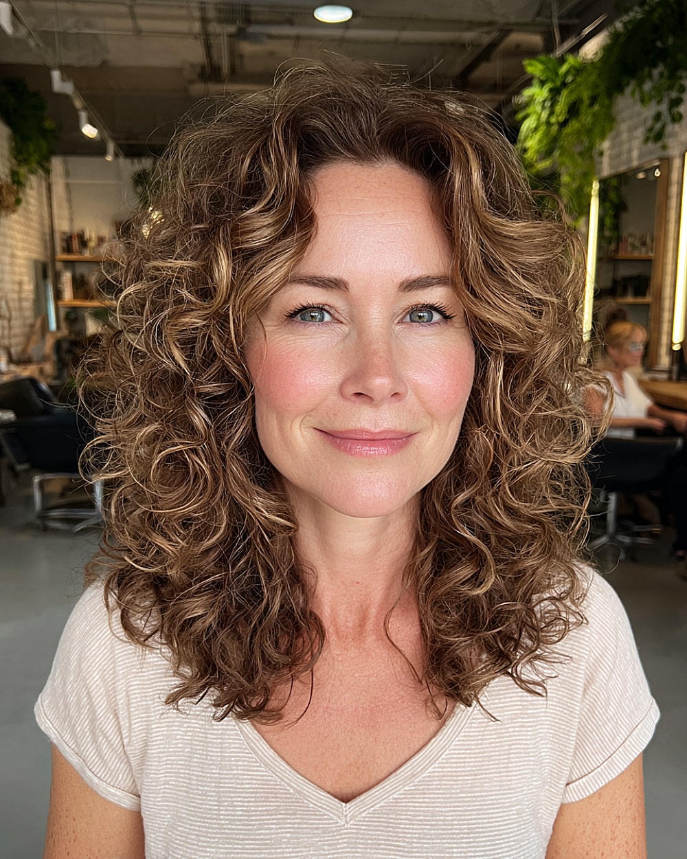 Mid length curly cut for women over 40 with soft layers and volume