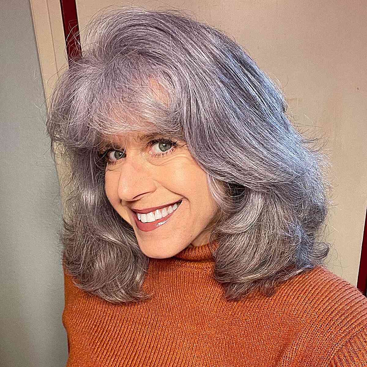 Mid-Length Silver Hair with Thick Layers and Light Bangs for Older Women