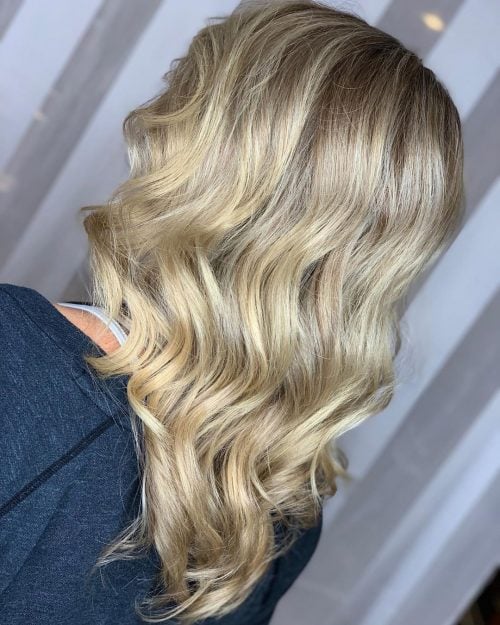 Soft mid-length wavy hair v-cut with blonde balayage