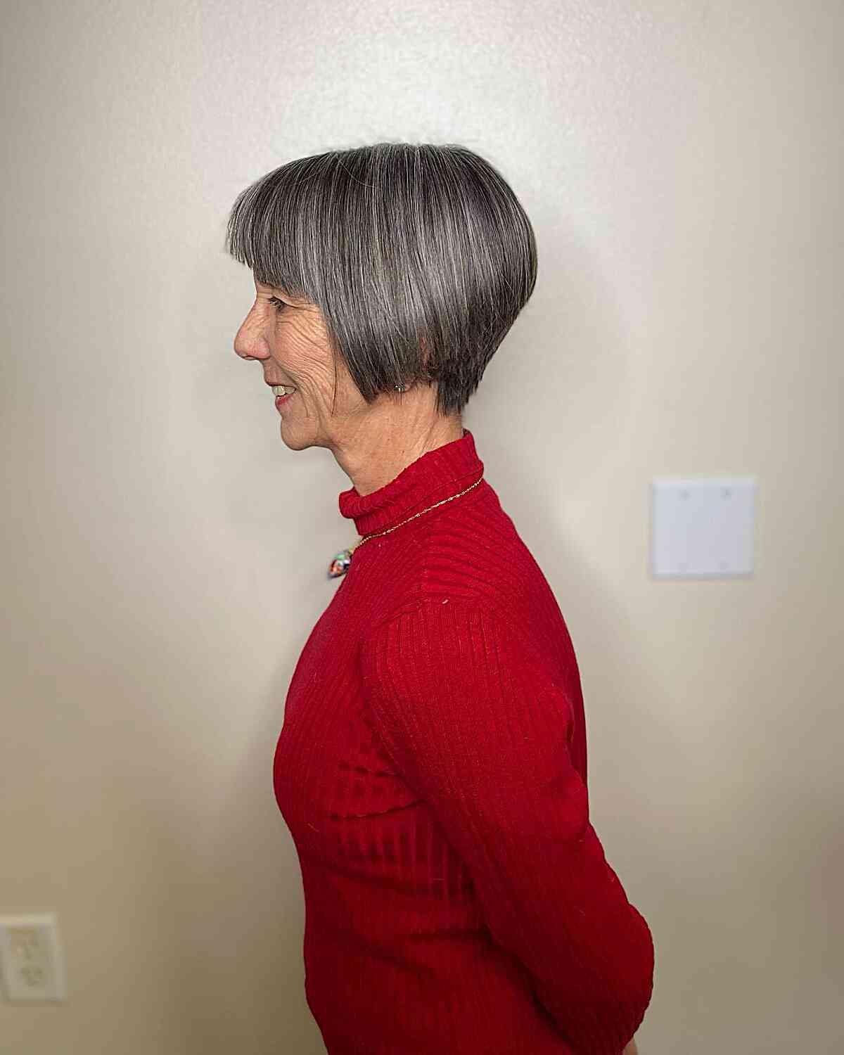 Jaw-Grazing A-Line Pixie Bob Featuring Sleek Bangs on Grey-Haired Older Women