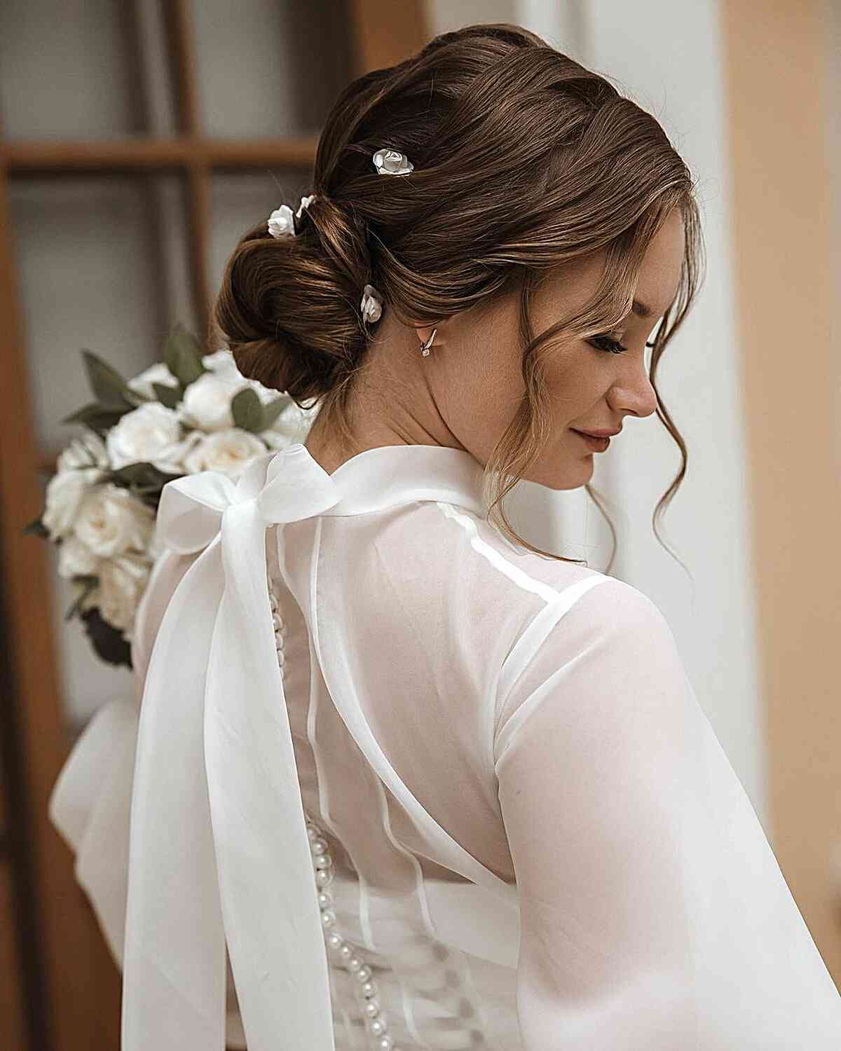 Adorable Bun Updo with Face-Framing Tendrils and Accessories for a Wedding