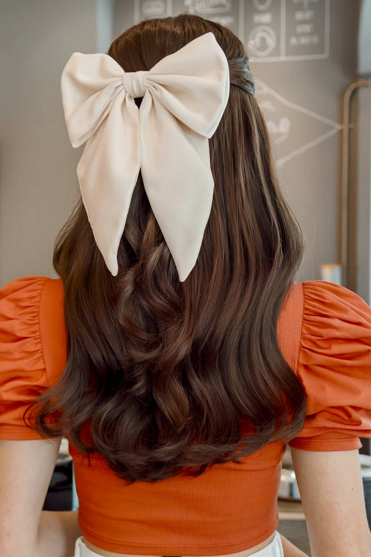 Charming hairstyle for long hair featuring a bow