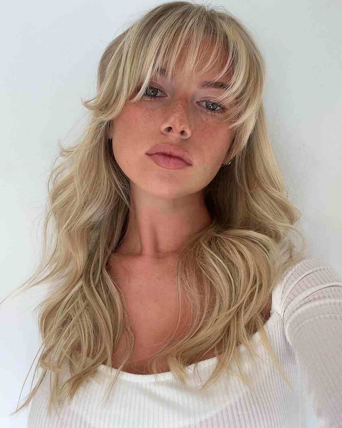 Alluring Creamy Blonde Beach Waves and Wispy Bangs