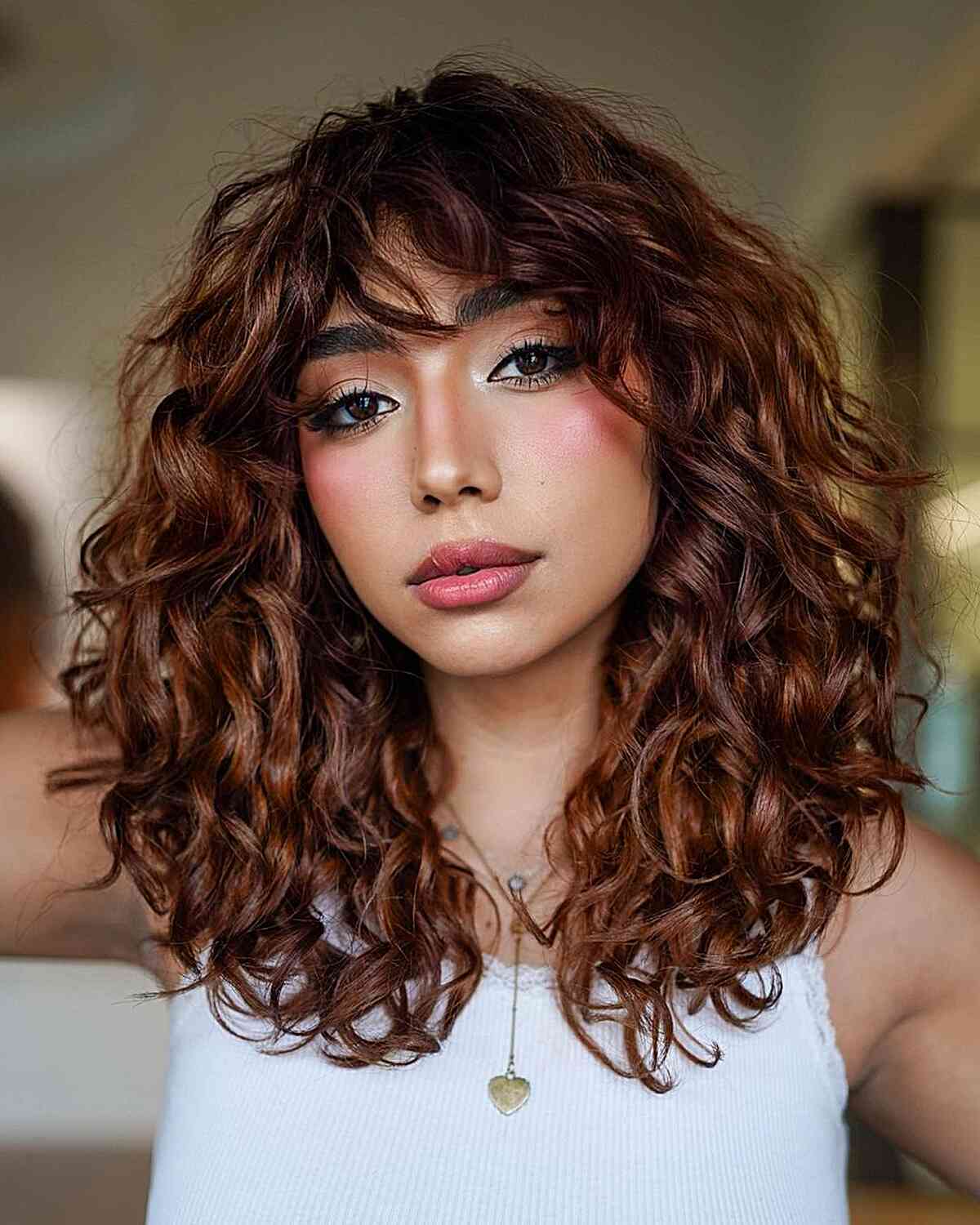 Beautiful Medium Curls with Flattering Side Bangs for women with prominent cheekbones