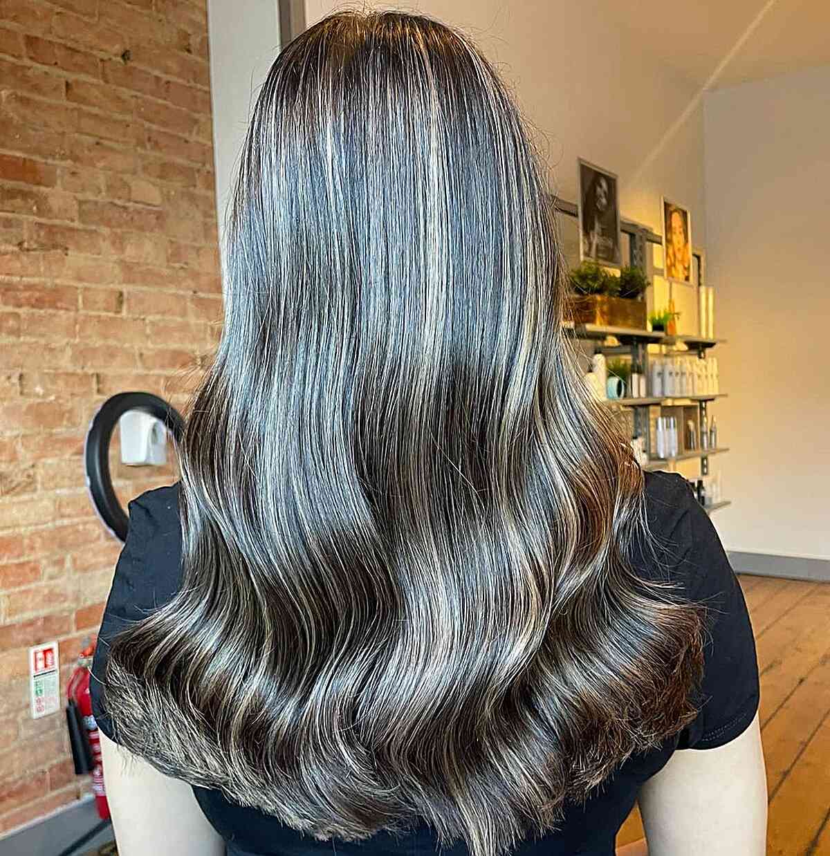 Brunette Balayage with Cool Undertones and Subtle Blonde Highlights for Mid-Back Wavy Hair