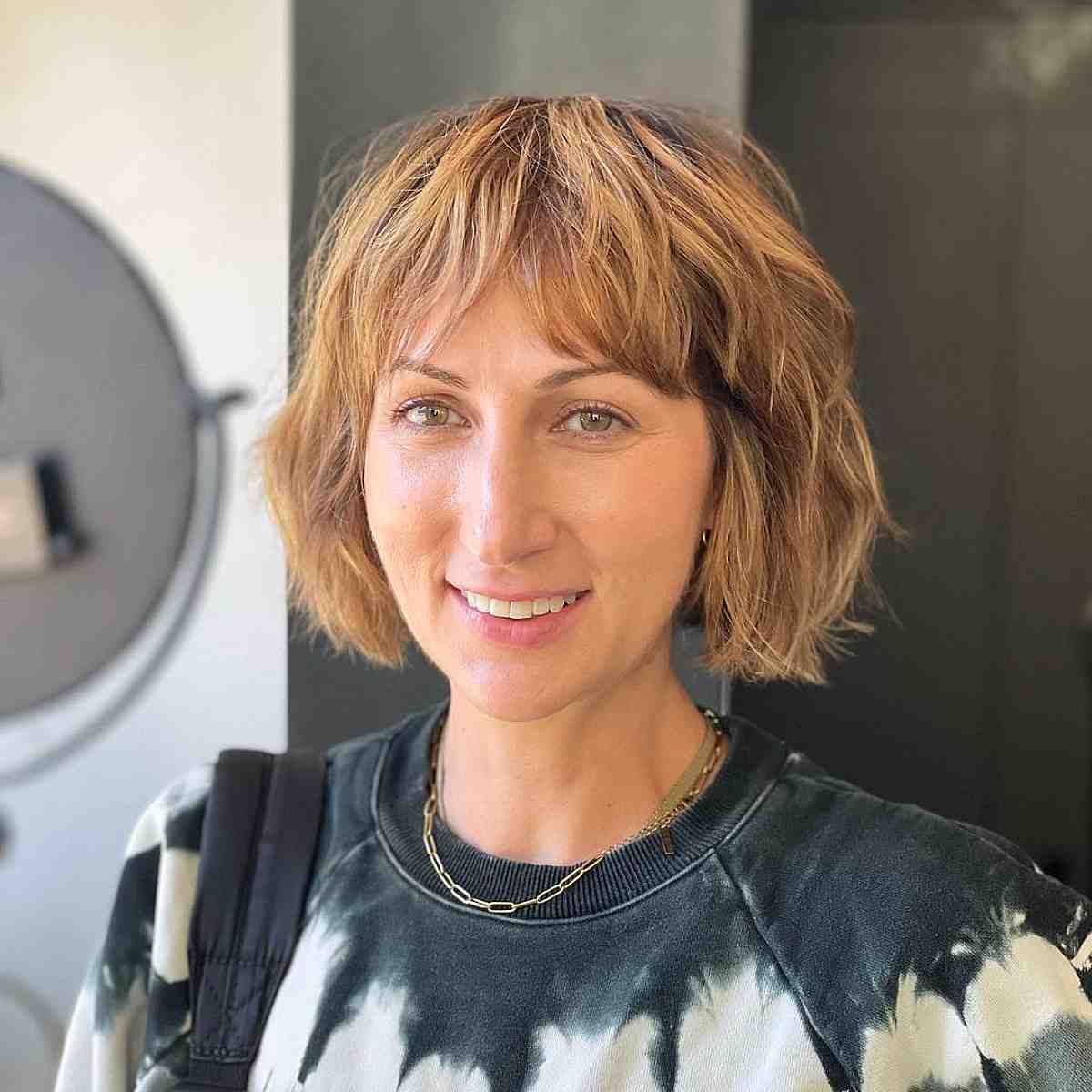 Chic Blonde Balayage on a Textured Layered Bob with Bangs