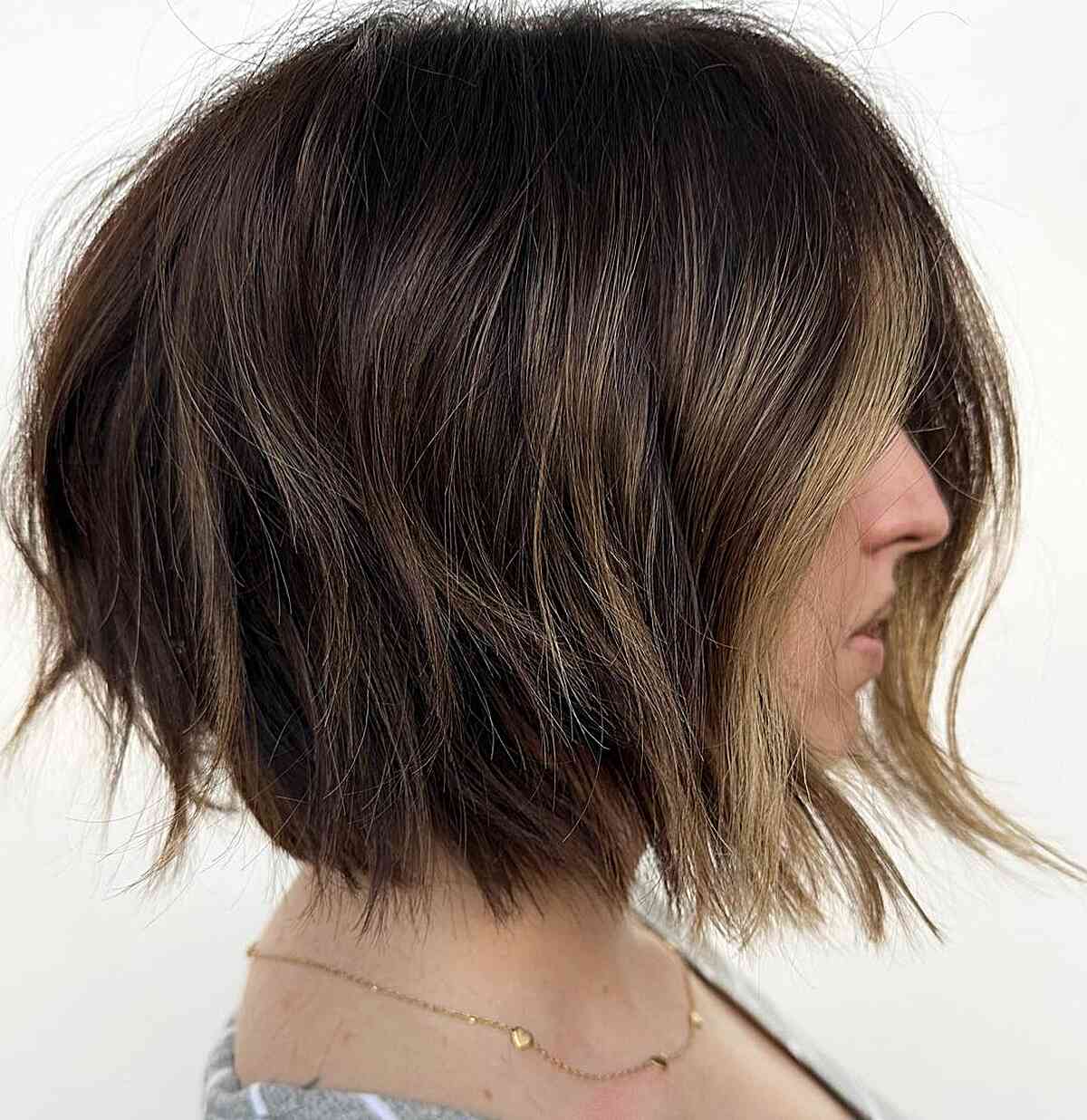 short, choppy bob with abundant volume and blunt ends featuring a money piece