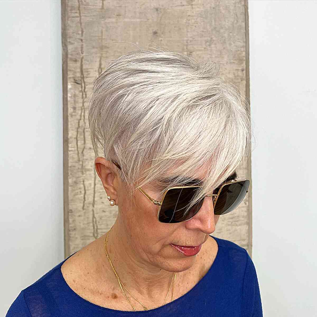 Stylish Platinum Pixie with Short Layers and sweeping fringe on mature women