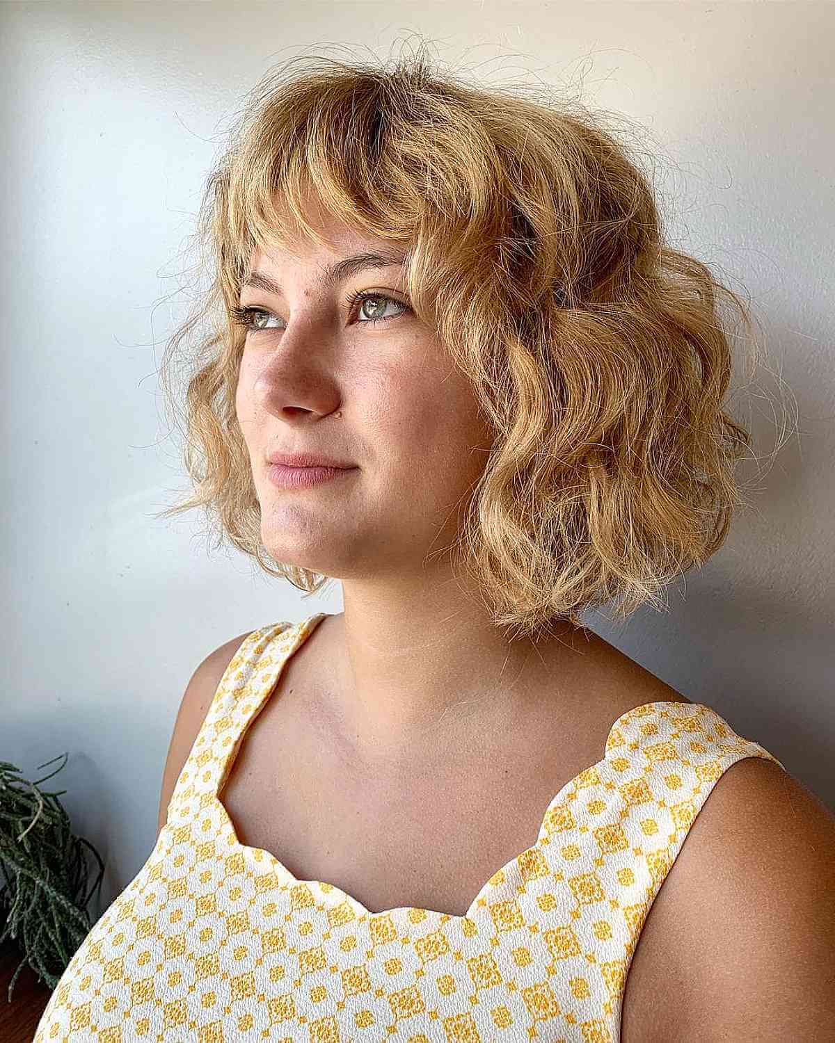 Chin-Length Bob Featuring Soft Curls and Layered Bangs