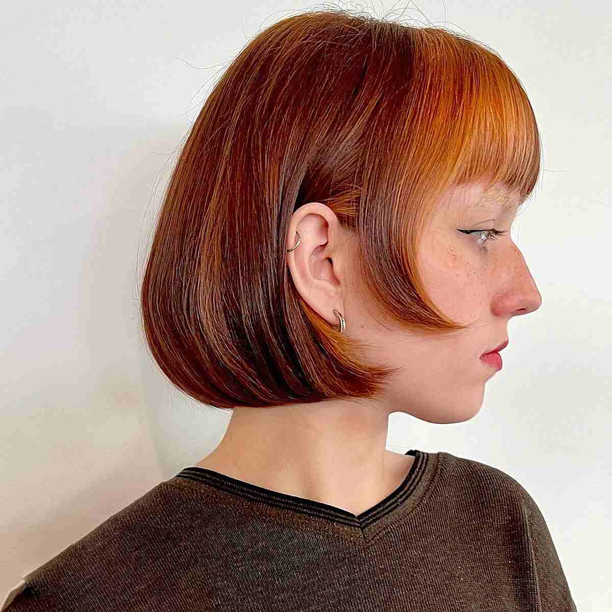 Chin-Length Copper Beveled Bob with Vibrant Orange Bangs