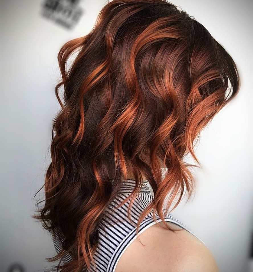 Copper-tinged red highlights on light brown hair