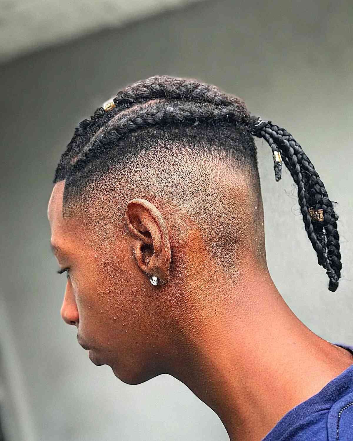 An image showcasing a black man sporting a distinctive cornrow braided bun hairstyle