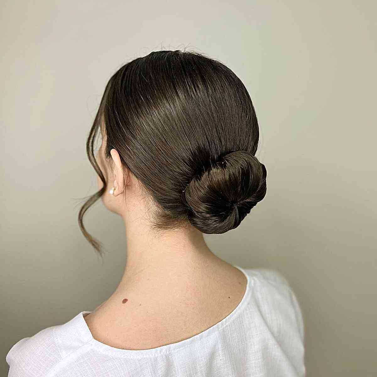 Effortless Elegant Ballerina Updo Bun with Face-Softening Strands on Dark Hair