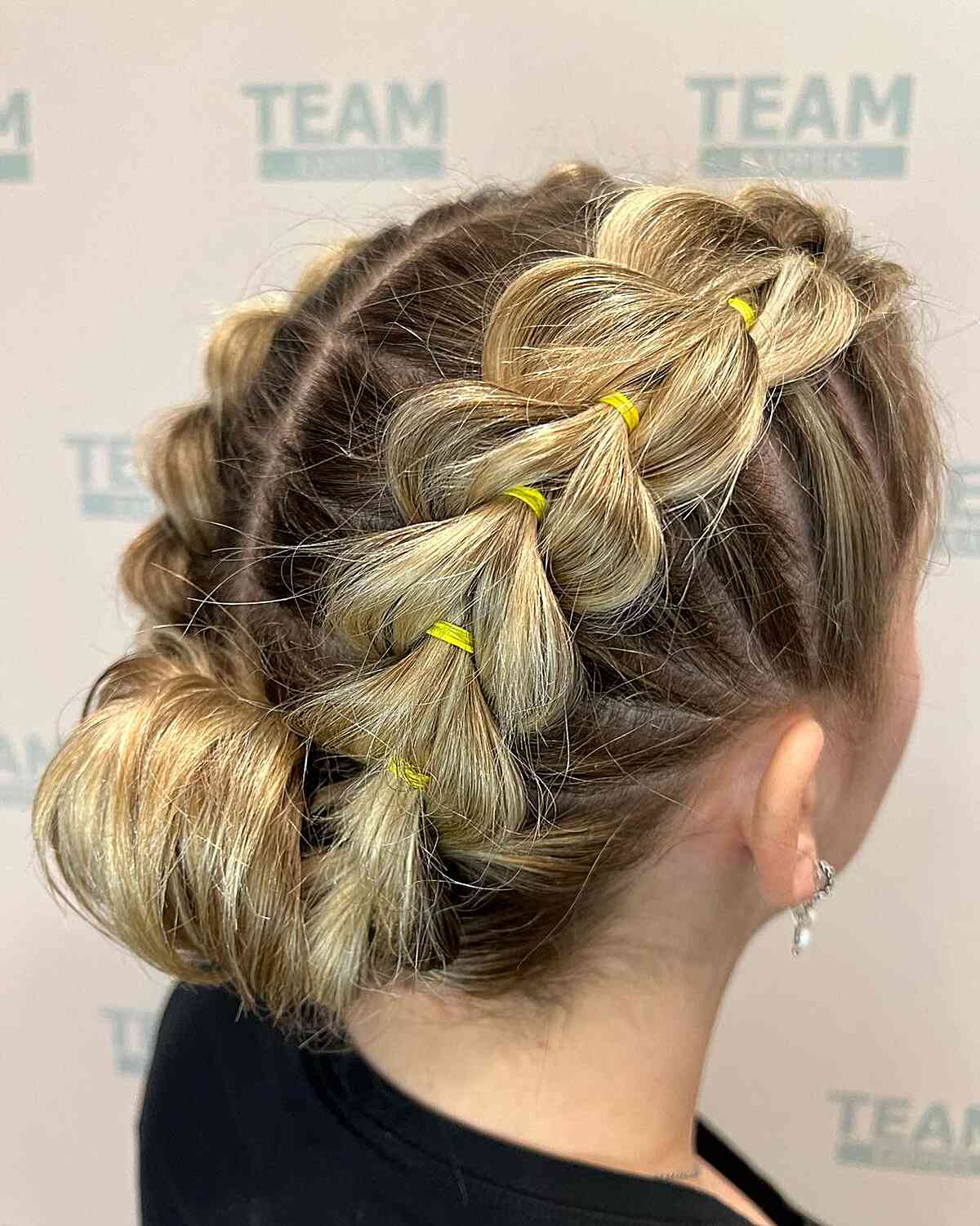 Elegant Double Pull-Through Braids and a Rolled Bun for Blondes with Medium Hair