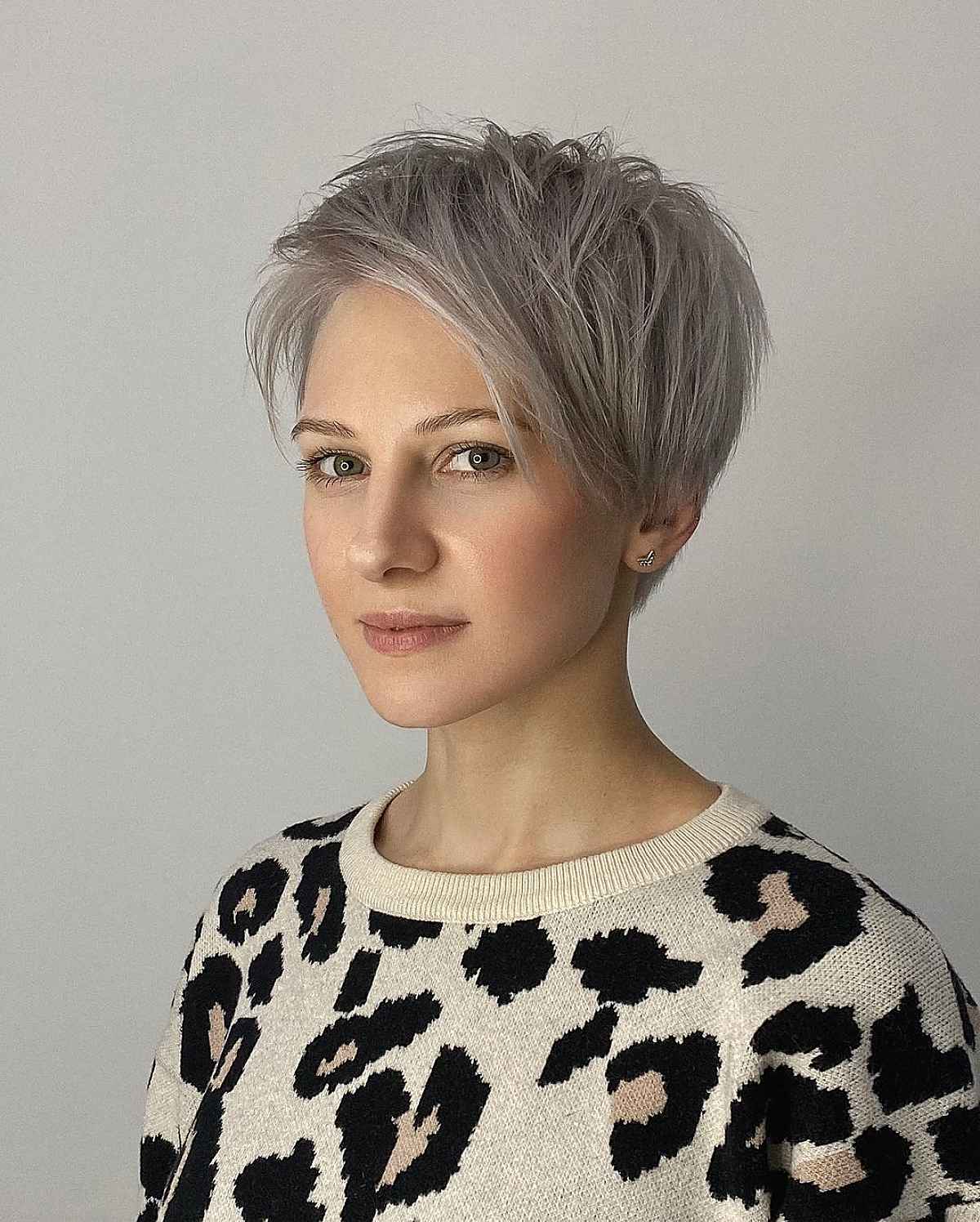 elegant silver blonde pixie cut with extended side-swept bangs