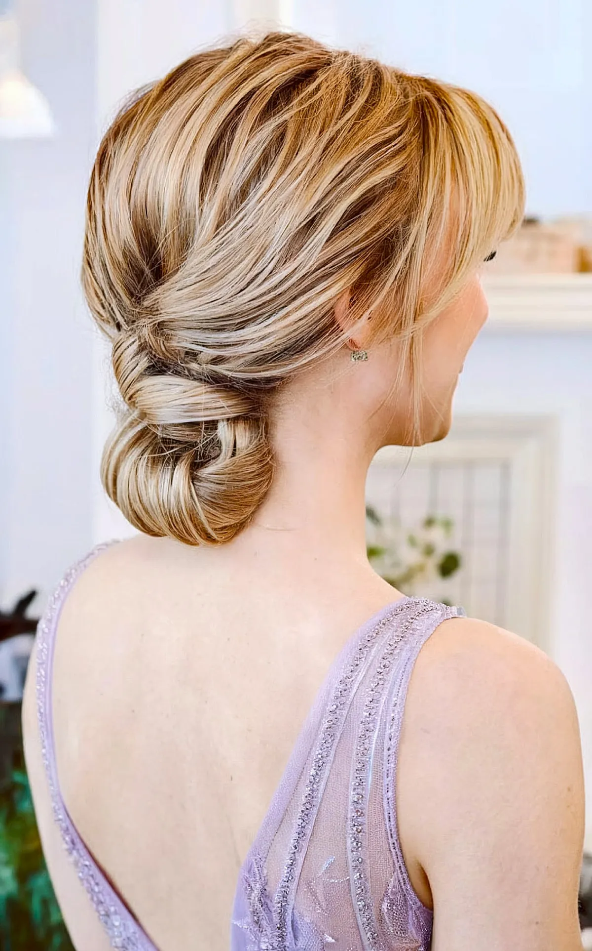 Elegant Wrapped Bun with Gentle Side Bangs for Straight, Thick Hair on Blonde Women