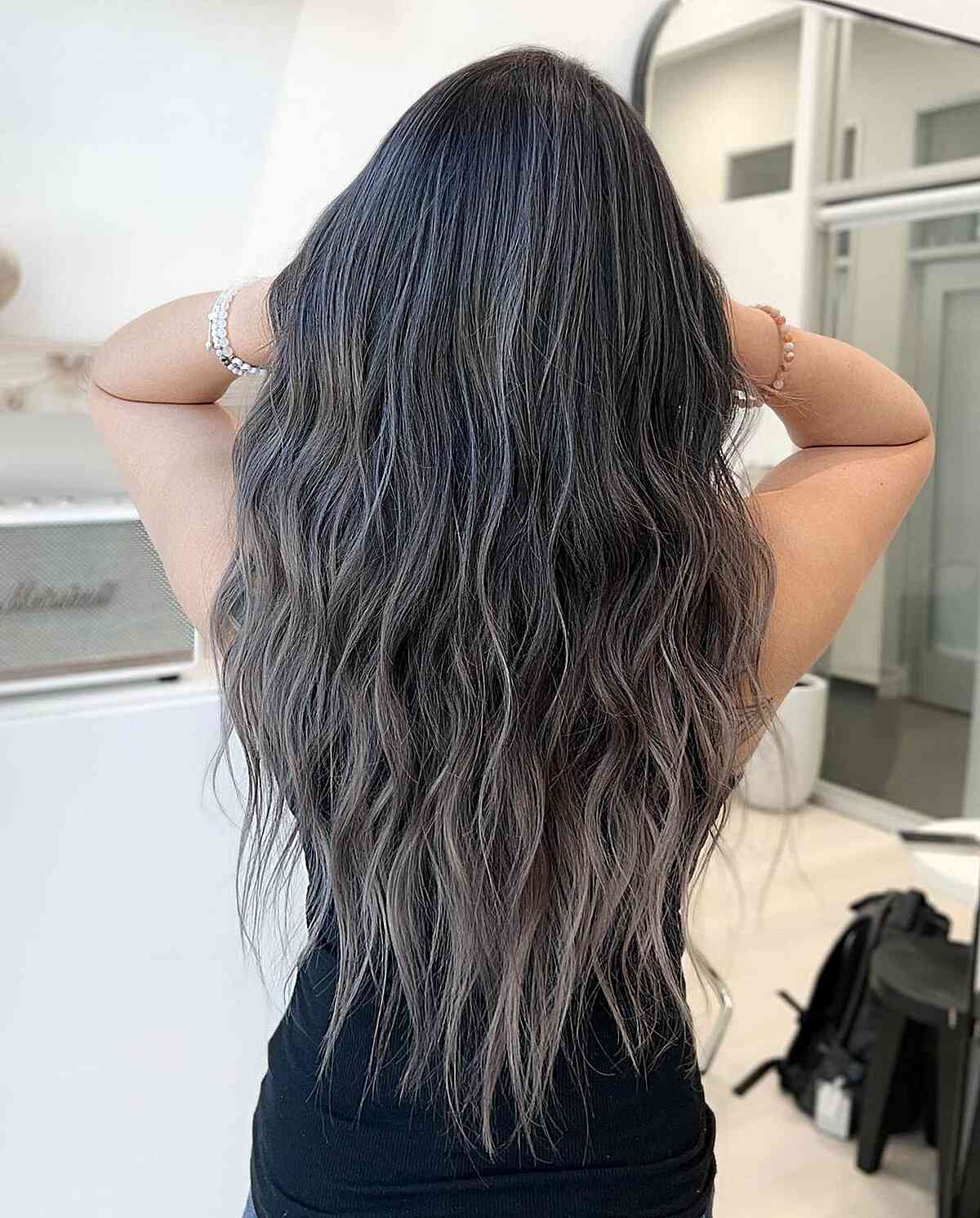 Enhanced Black Locks with Subtle Highlights for women with long wavy hair