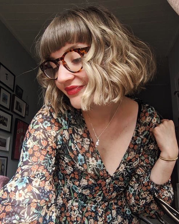 Fashion-forward shaggy bob with straight bangs for a round face