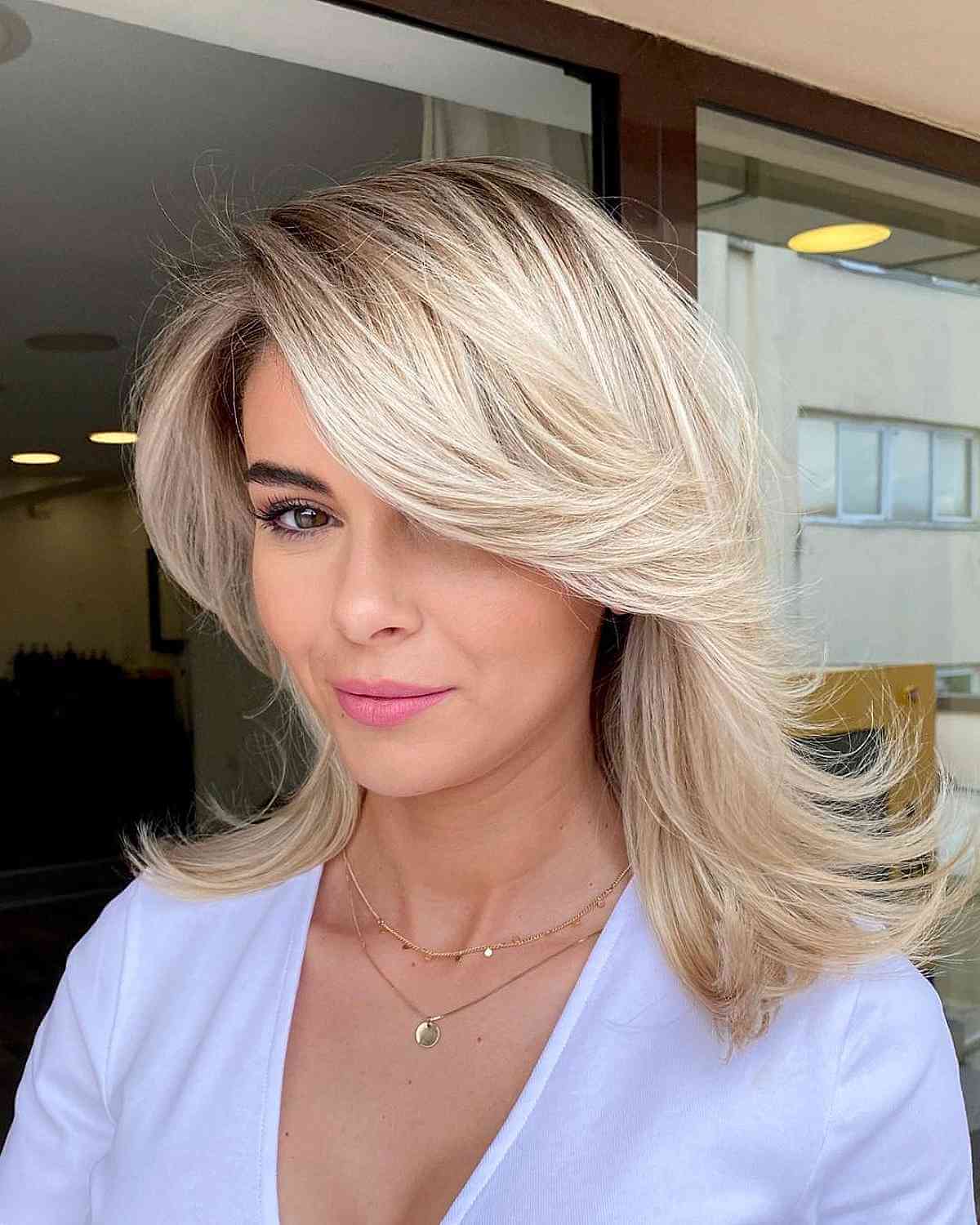 Feathered Blonde Layers with a Side Swept Bang