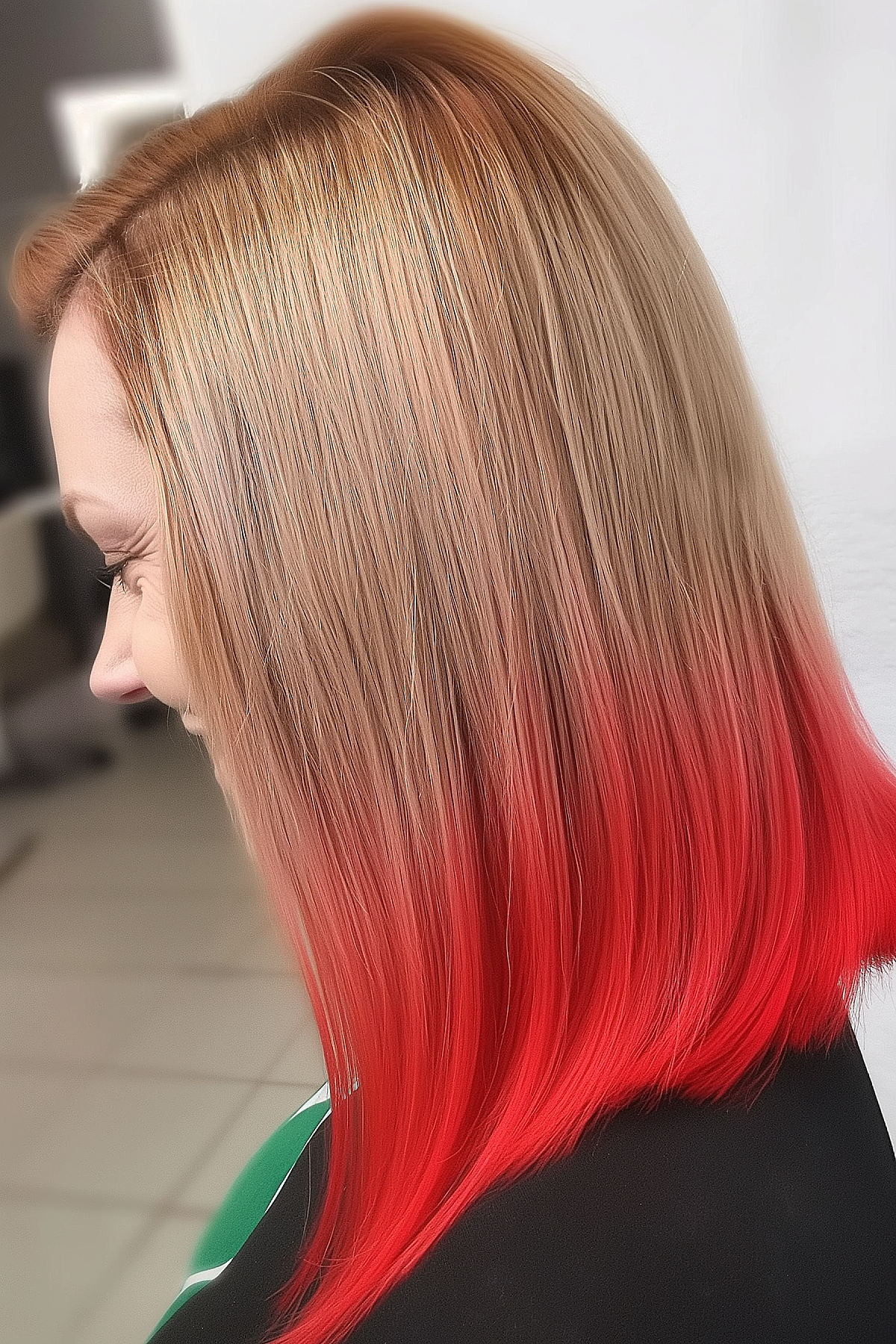 Medium-length blunt cut featuring reverse blonde to fiery red ombre styling