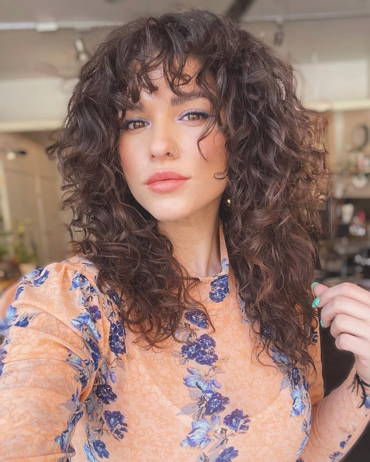 Curly mid-length hairstyle with wispy fringe