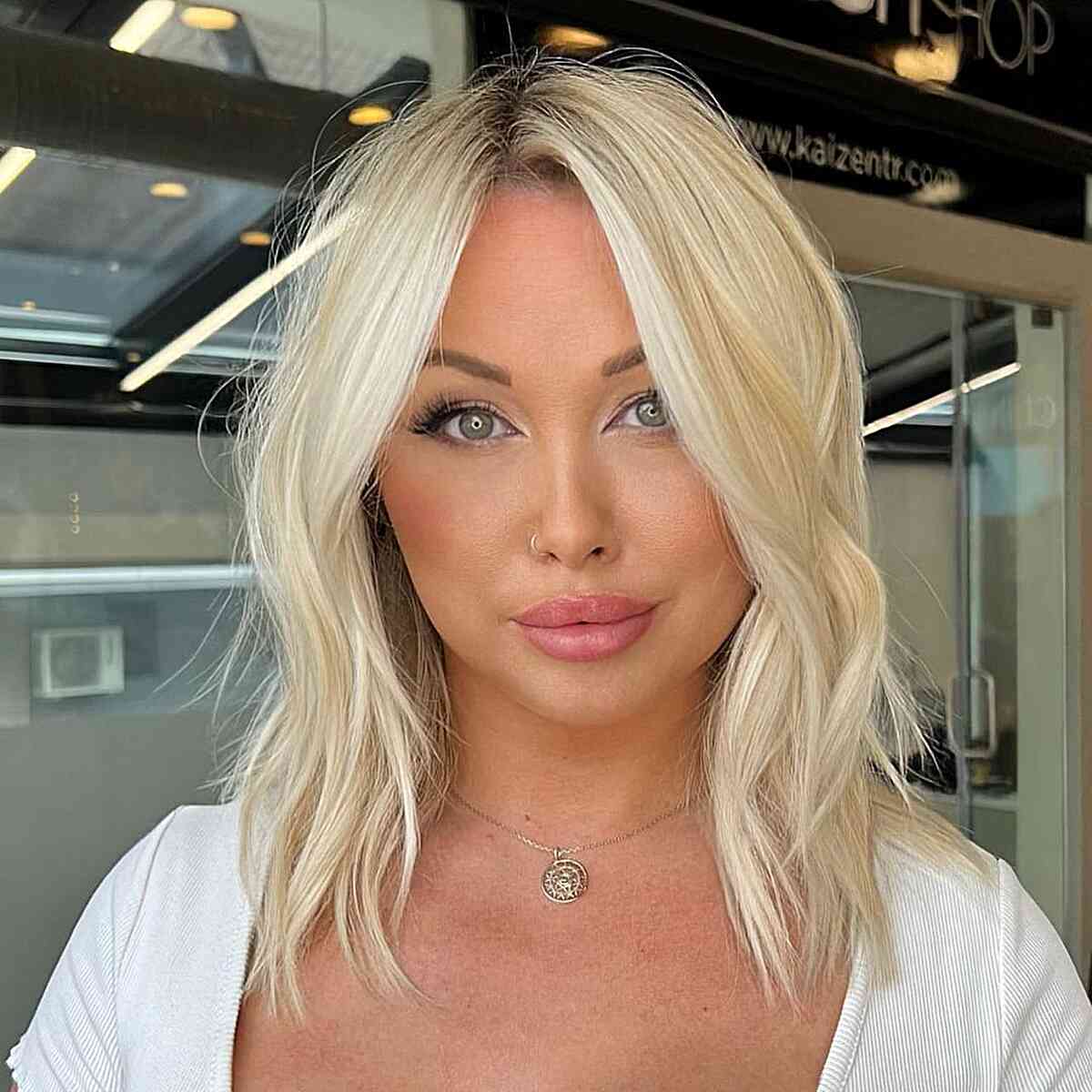 Light Baby Blonde Collarbone-Length Elegance featuring a middle part and choppy ends