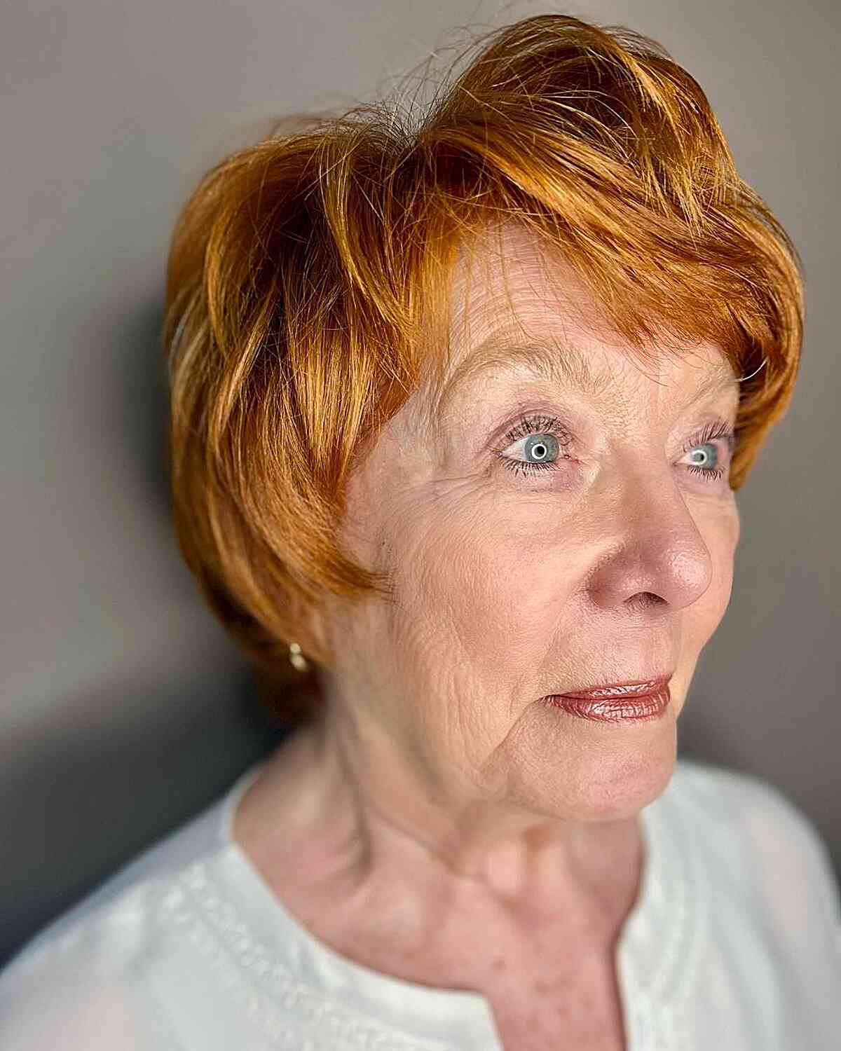 Luxurious Copper Voluminous Pixie Hairstyle with Side Part Style for 70-year-olds
