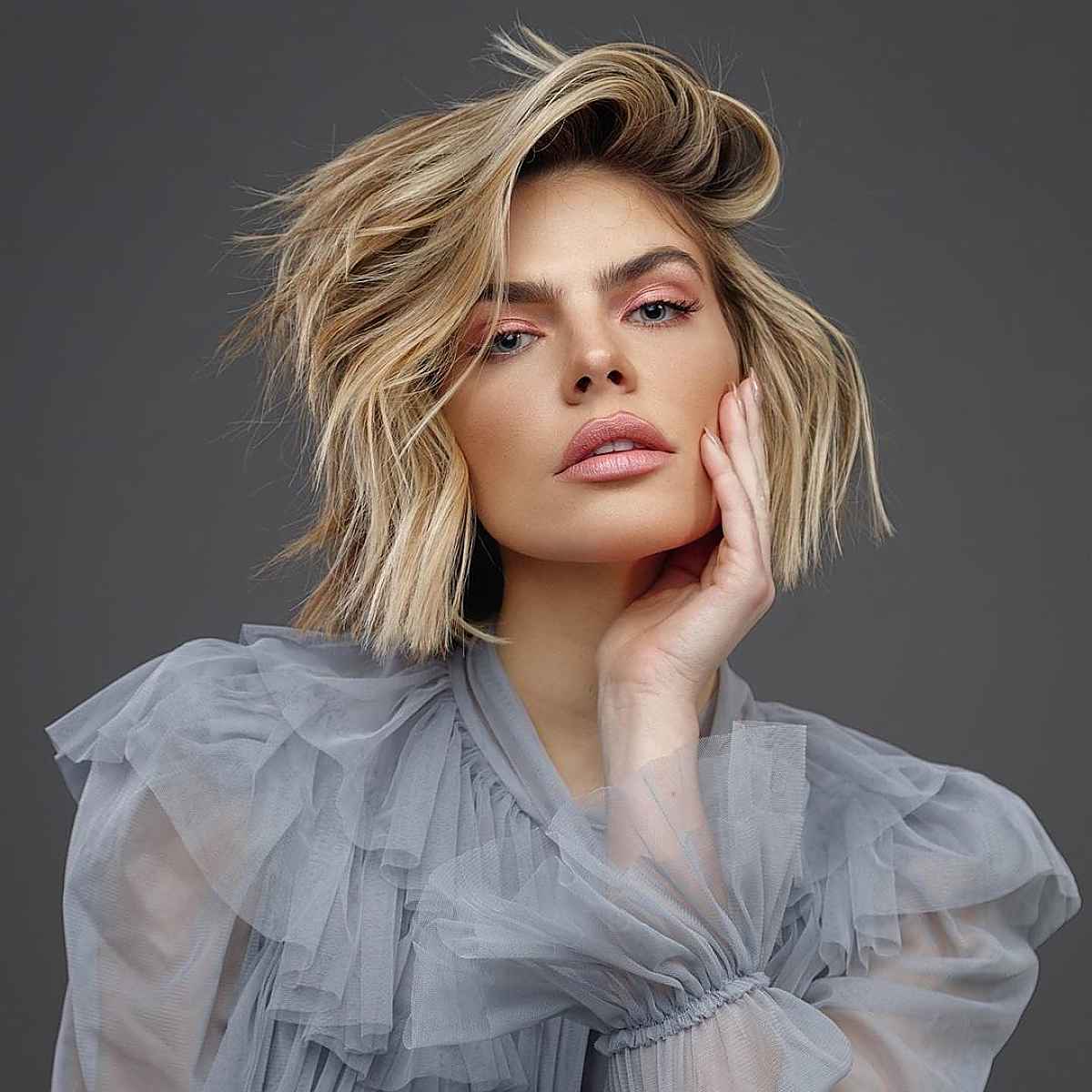 voluminous short blonde hair with dark roots