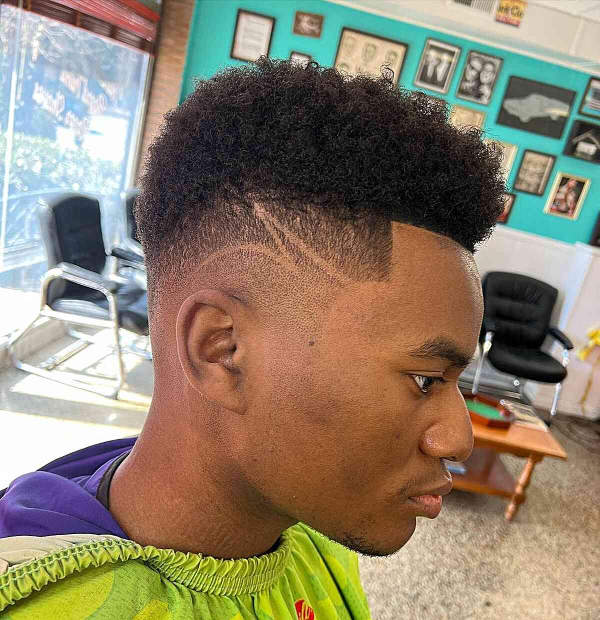 Image of a black man showcasing a drop fade haircut complemented by a surgical line