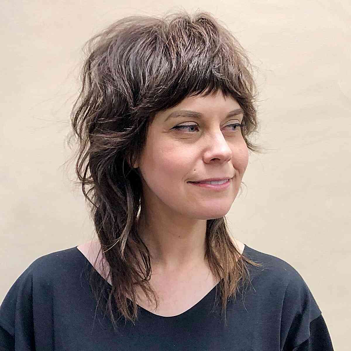 Medium Shag Shullet featuring textured razor cut layers and bangs for women over 40