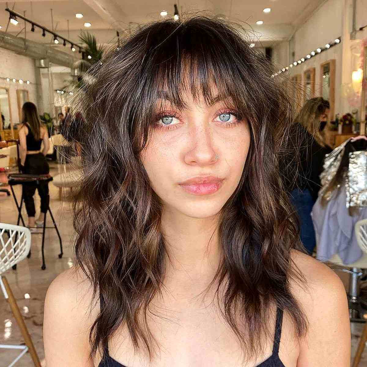 Medium Wavy Hair Featuring Long Layers and Bangs