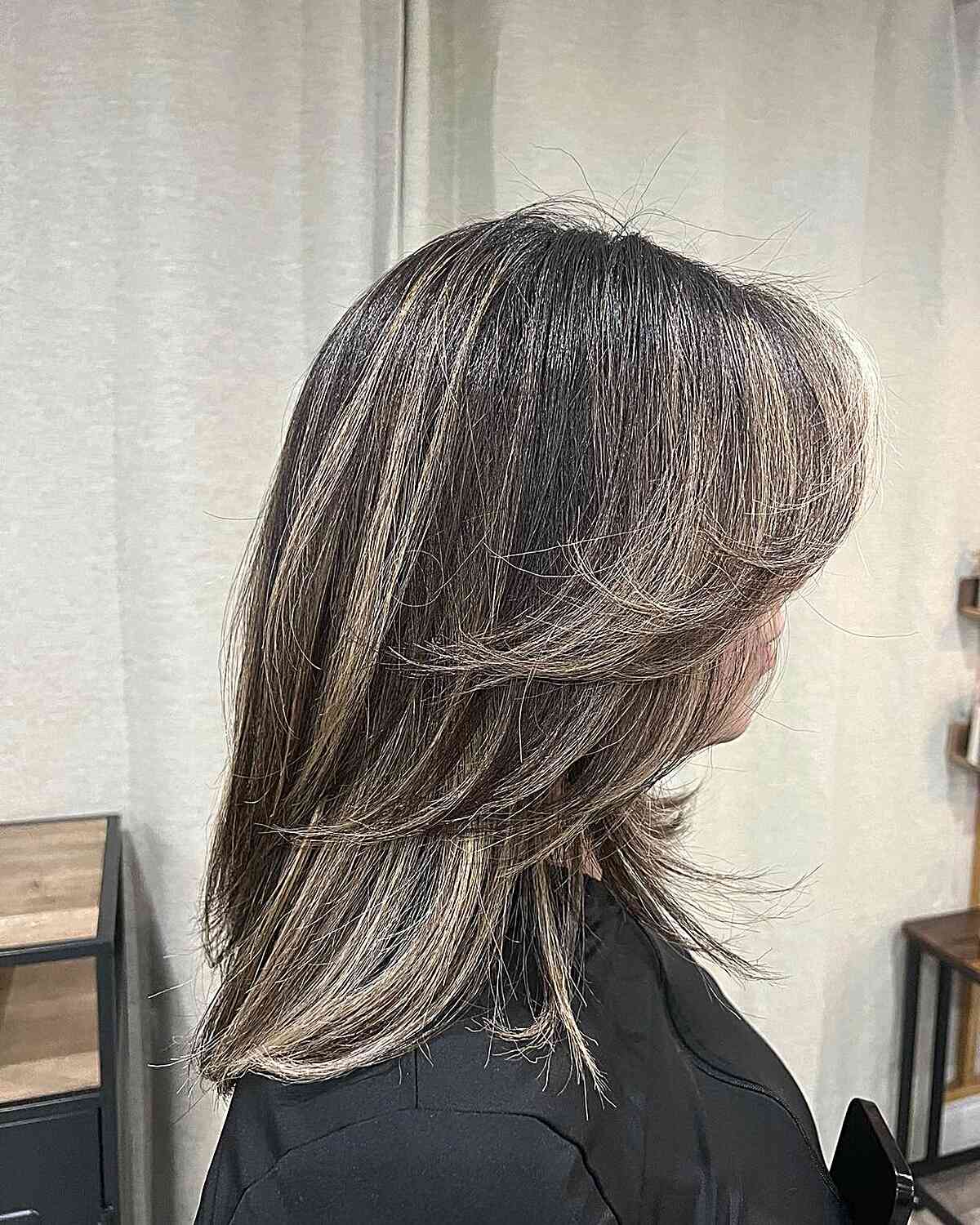 Mid-Length Black Feathered Hair Enhanced with Blonde Highlights
