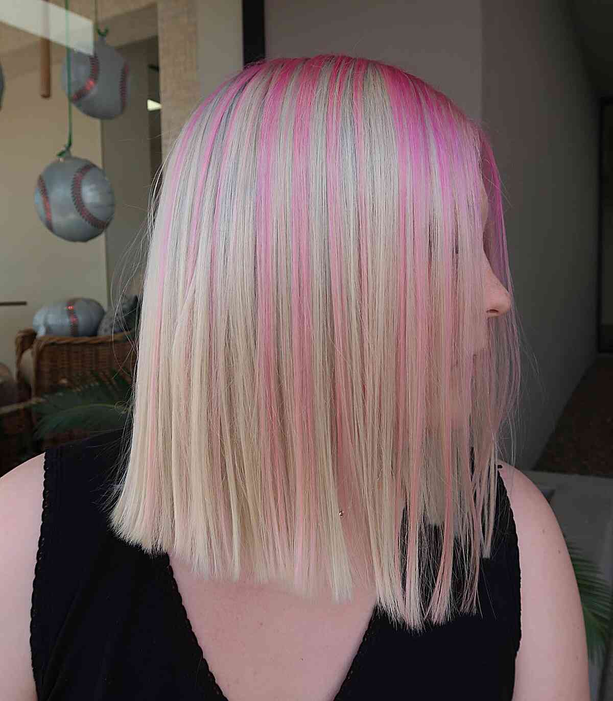 Playful Pink Strands Hair Color Idea for ladies with a long bob cut