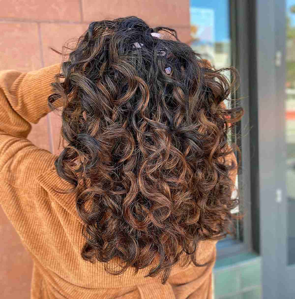 Rich Copper Highlights on Curly Dark Balayage Hair