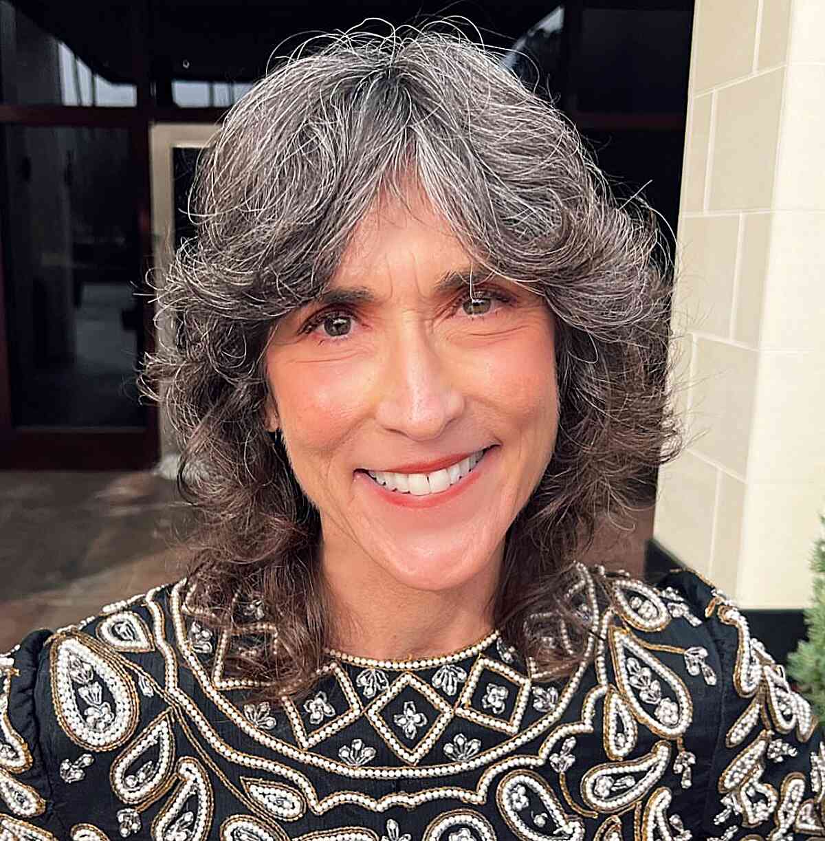 Shorter-Length Shag Hairstyle with Upswept Layers and Curtain Bangs for Older Women with Gray Hair