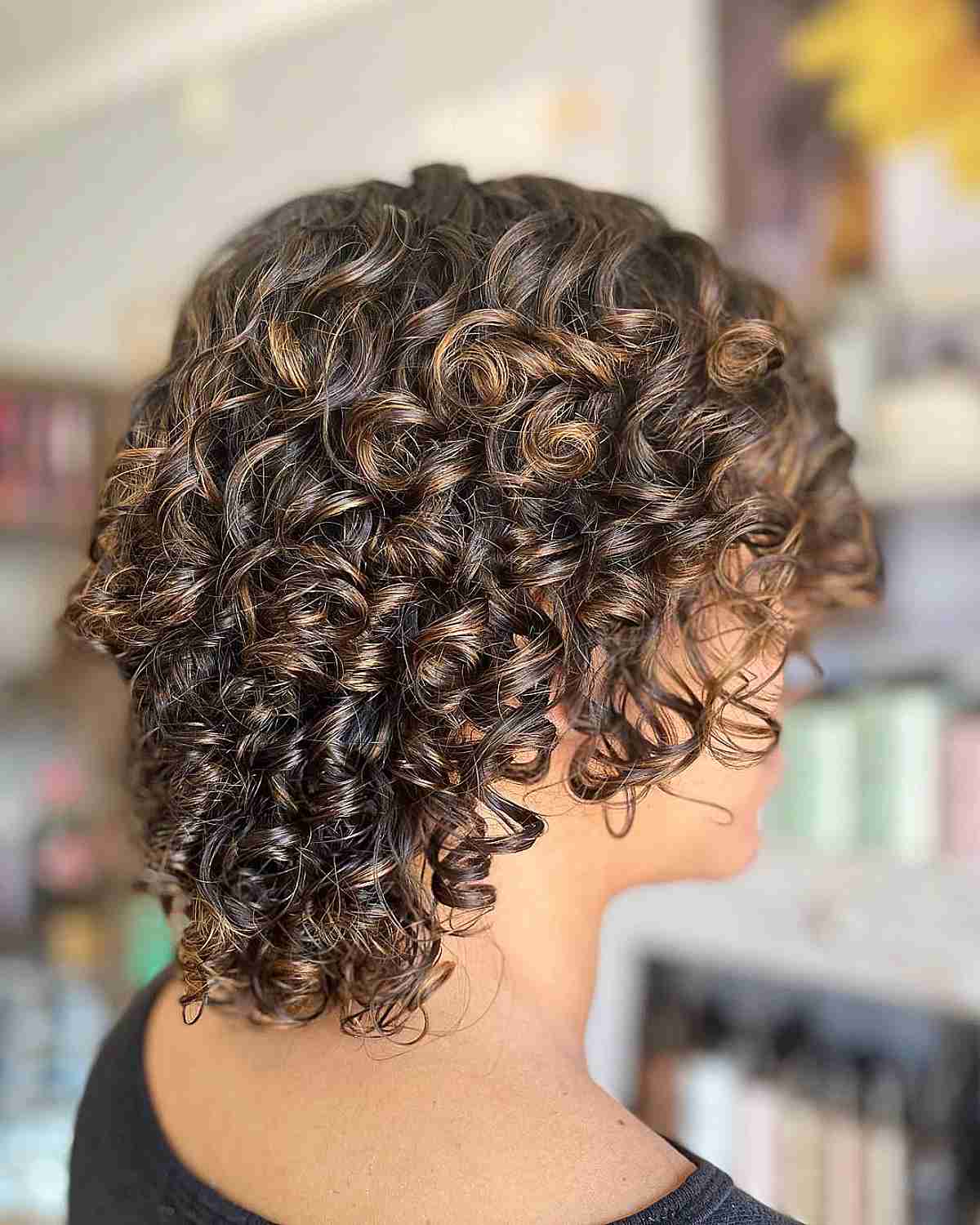 Short Layered Curly Hair with Gentle Honey Highlights Balayage