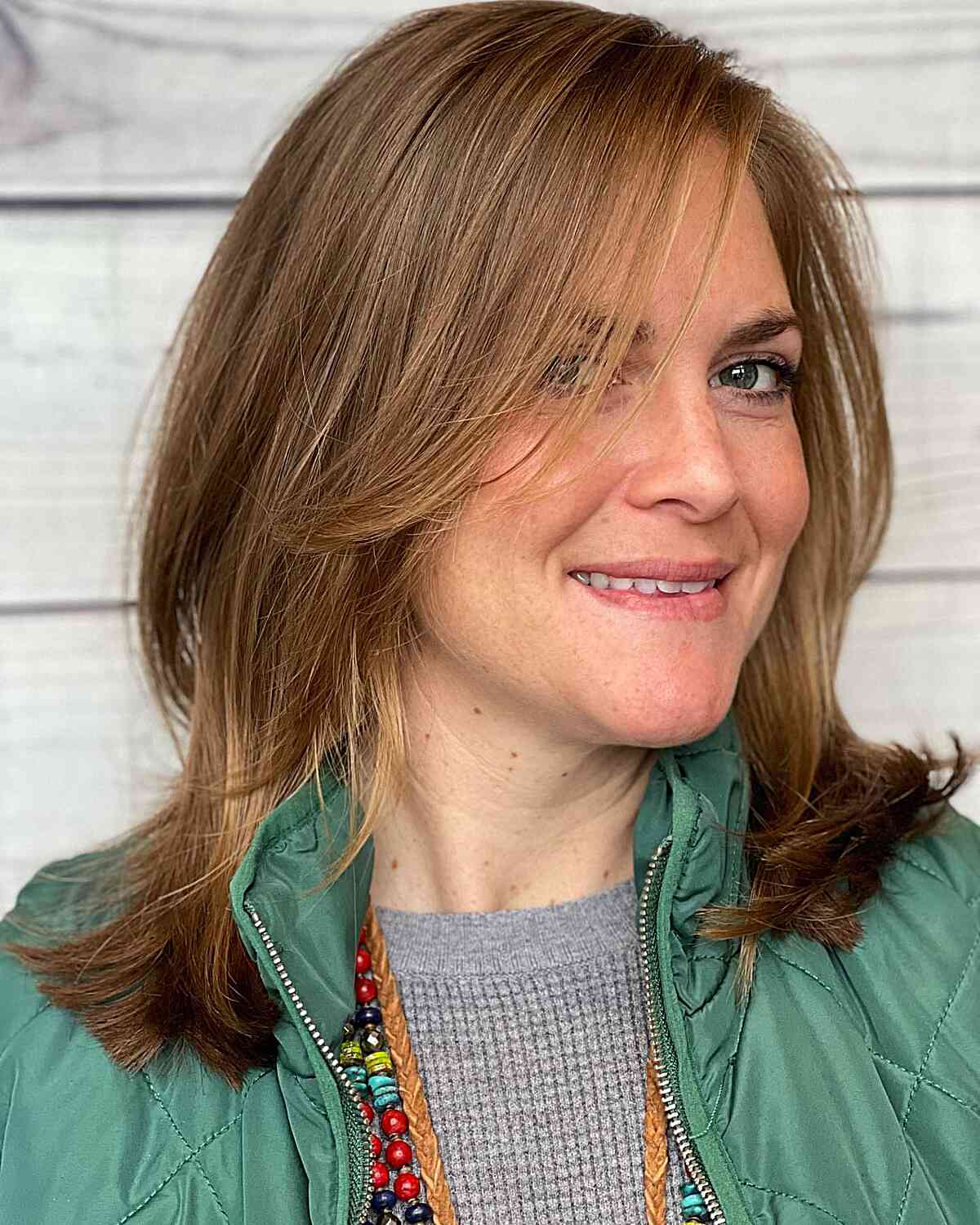 A woman with an oval face showcasing a shoulder-width hairstyle