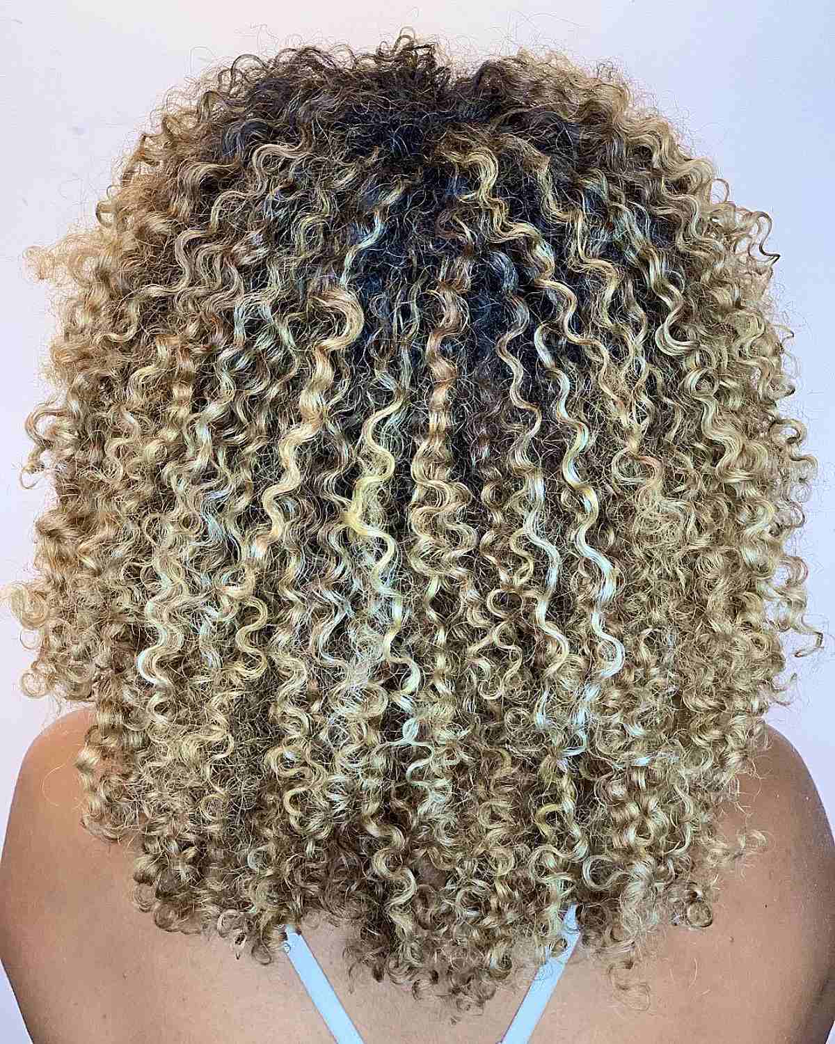 Balayage Spiraled Curls with Medium Blonde Highlights
