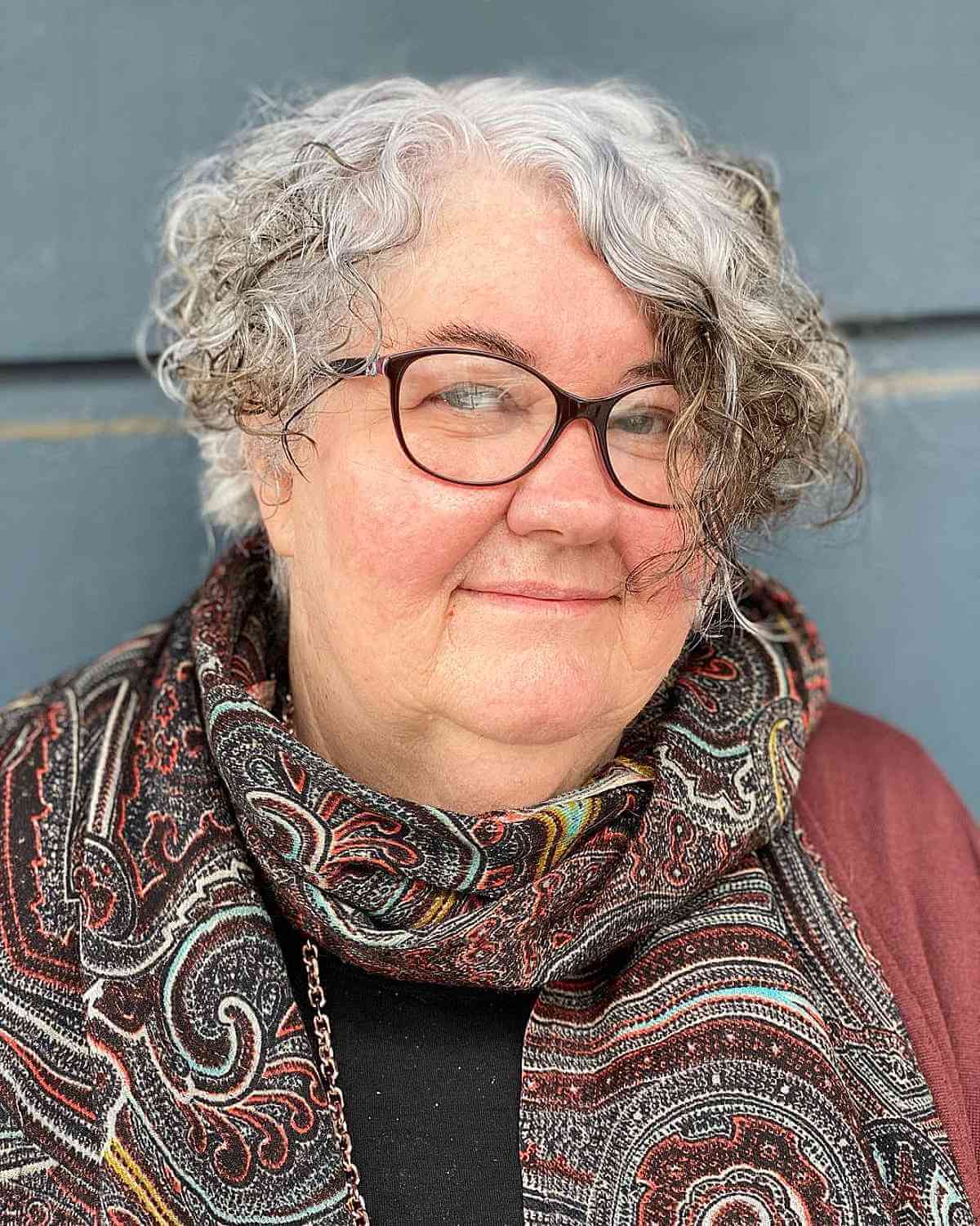 Stylish Asymmetrical Curly Hairstyle for Round Faces for 60-Year-Olds