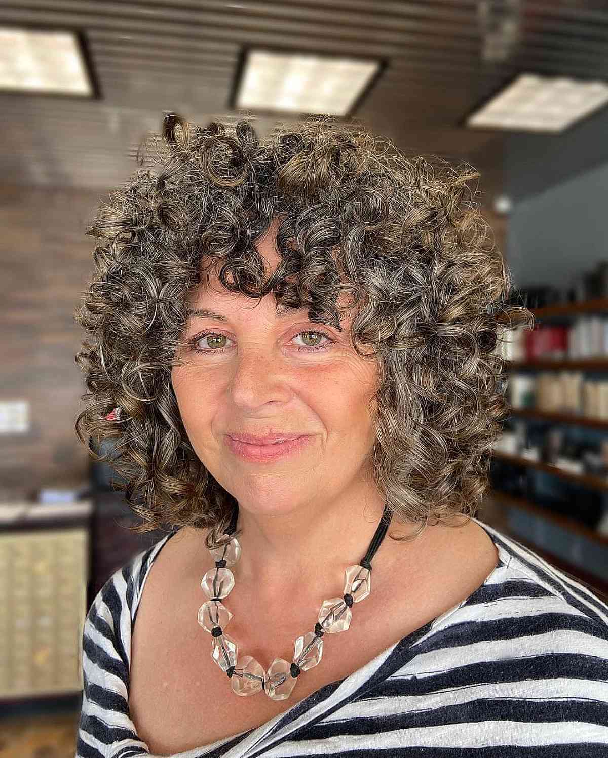 Stylish Grey Curly Hair with Bangs for Mature Women