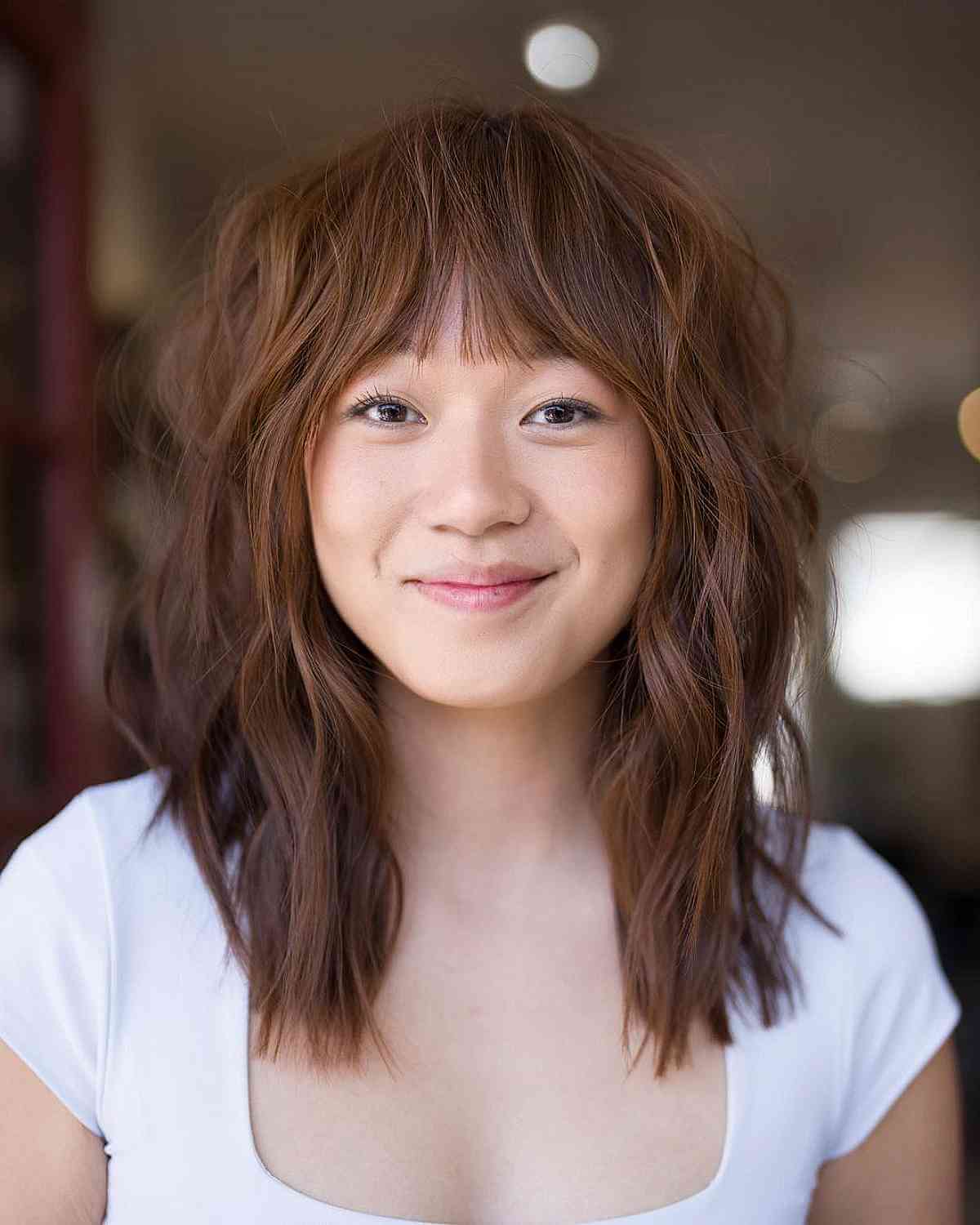 Stylish Medium Shaggy Strands with Delicate Bangs for Round Faces