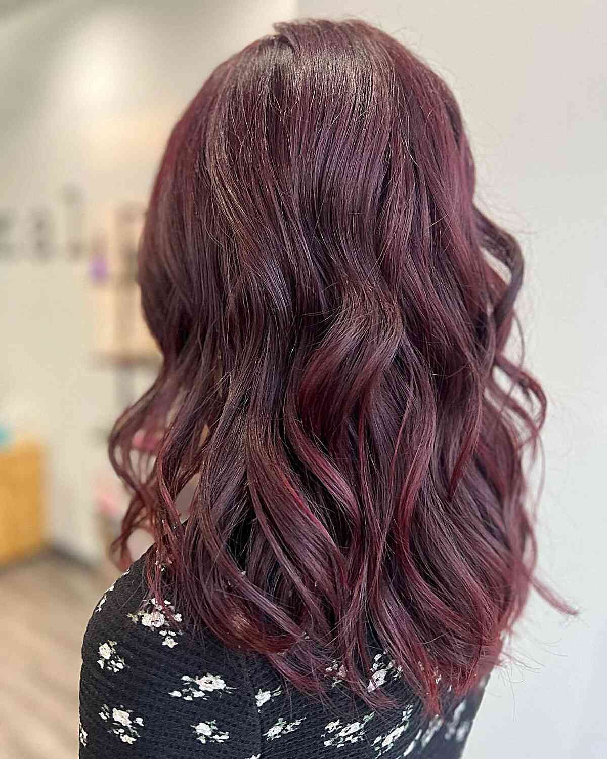 Subtle Burgundy Red Locks with Gentle Waves on Medium-Length Haircut