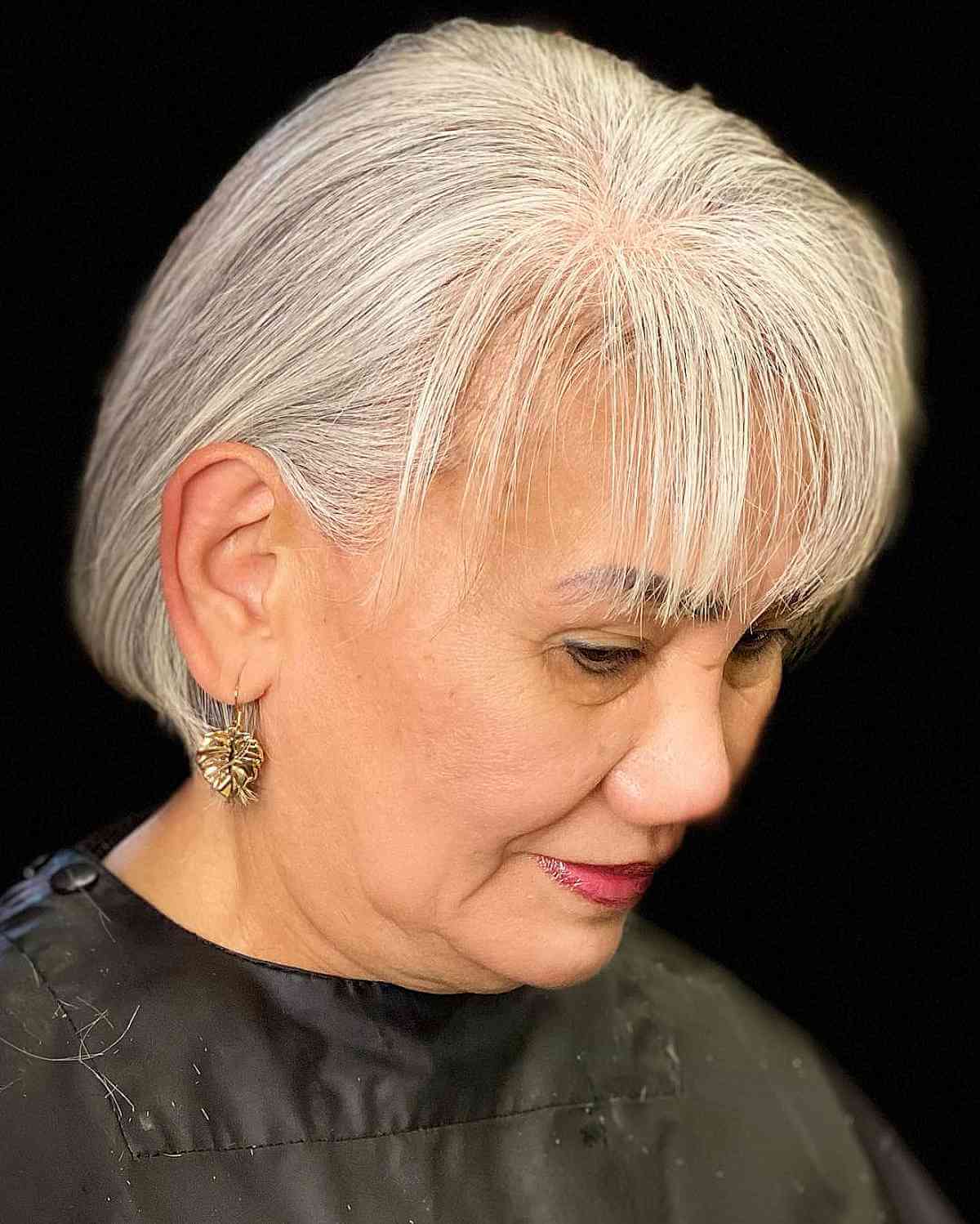 Grey Subtle Highlights with Wispy Bangs for a Woman Over Sixty