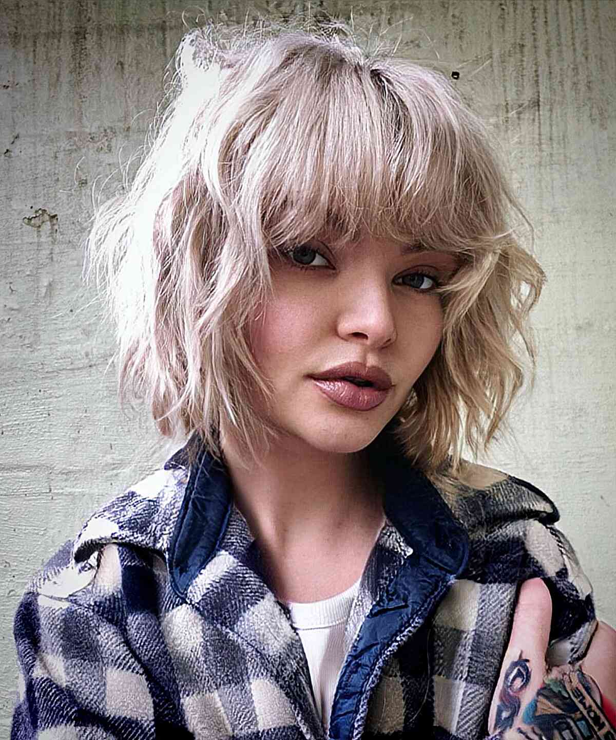 Stylish Textured and Tousled Platinum Bob with Bangs for a carefree look
