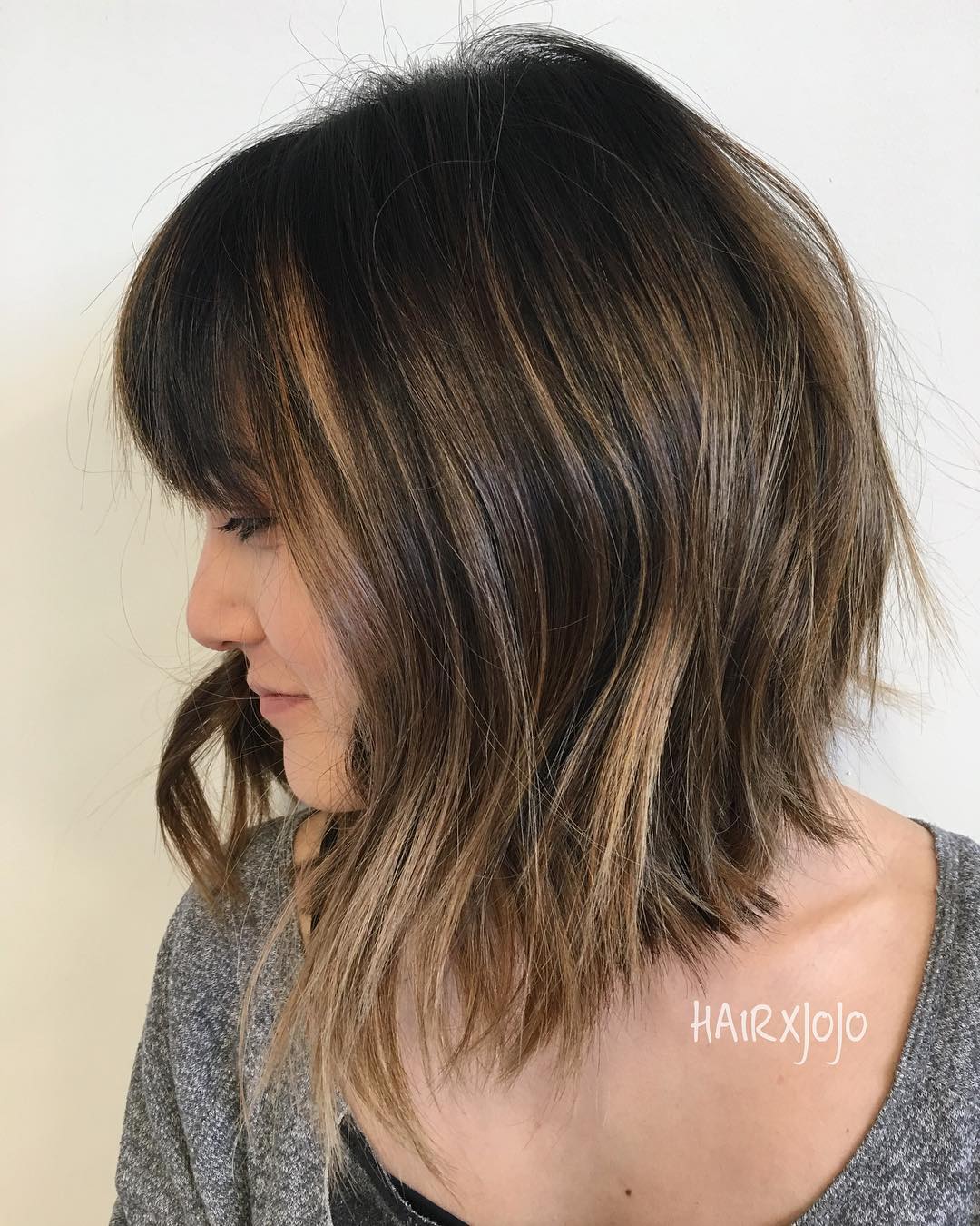 textured stacked long bob featuring choppy bangs