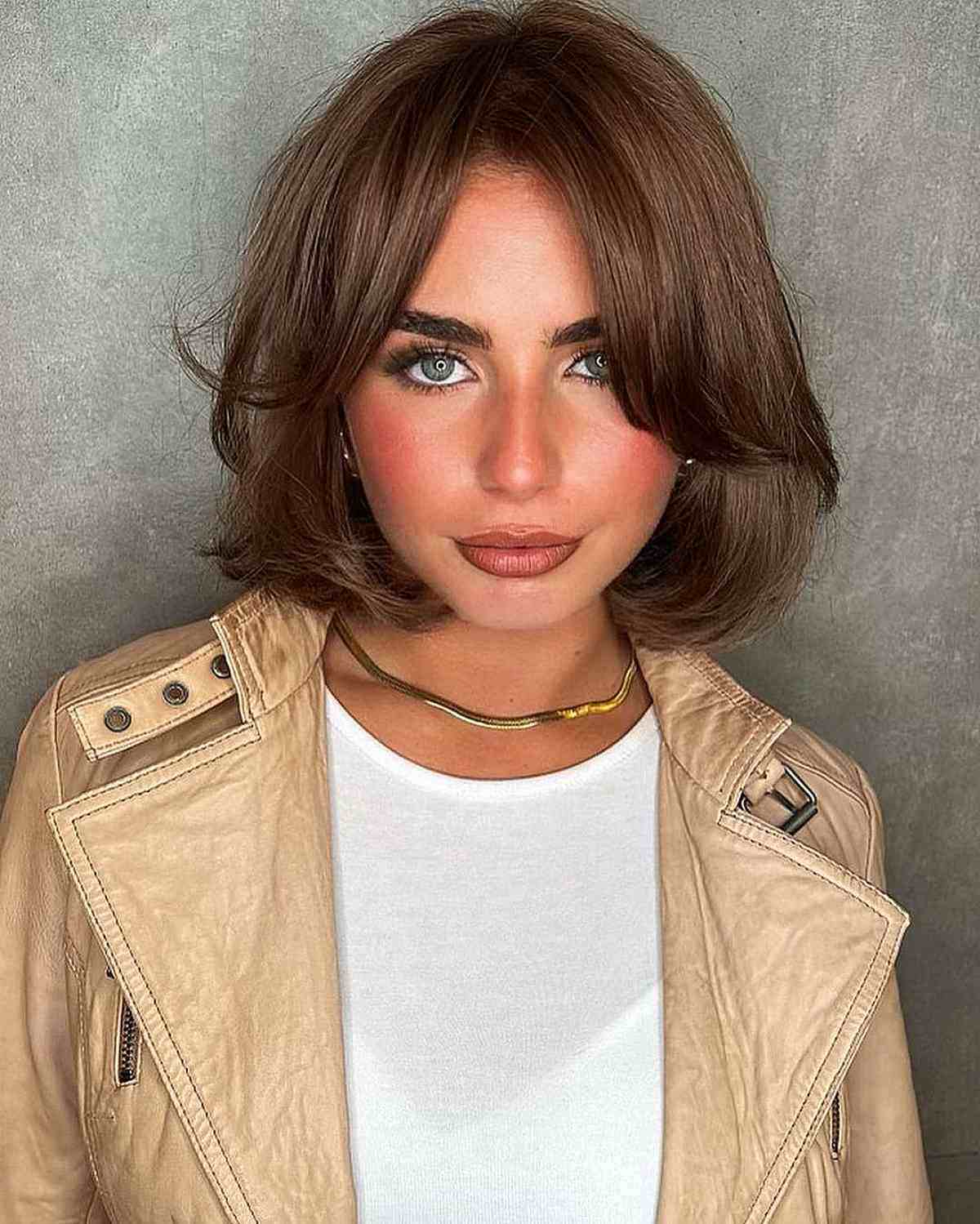 Timeless short bob hairstyle featuring curtain bangs and a voluminous gender neutral look