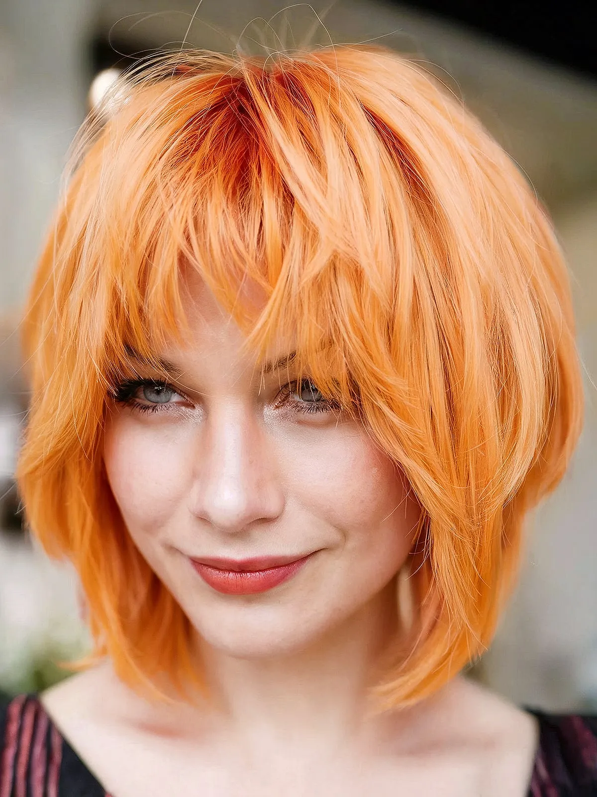 Short Vibrant Orange Layered Bob with Bangs for women with a bold style
