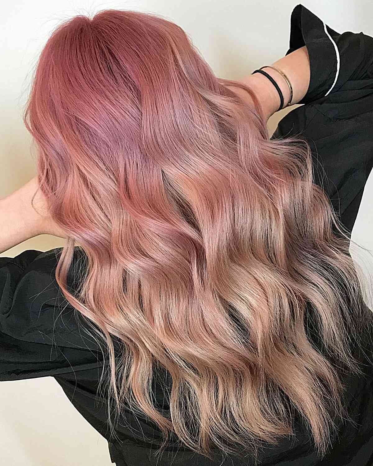 Vibrant Pink Lemonade Balayage on long wavy hair with wispy ends
