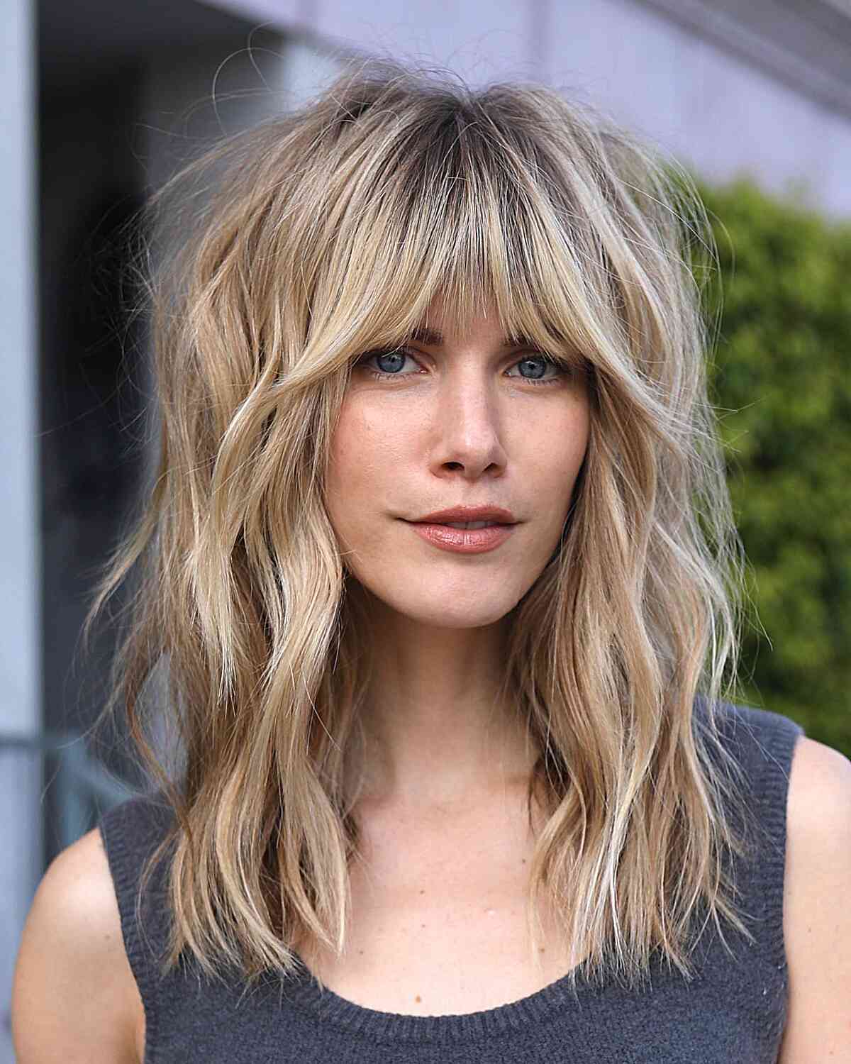 Voluminous Shaggy Hairstyle with Bangs Stylish Looks for women with mid-length wavy hair